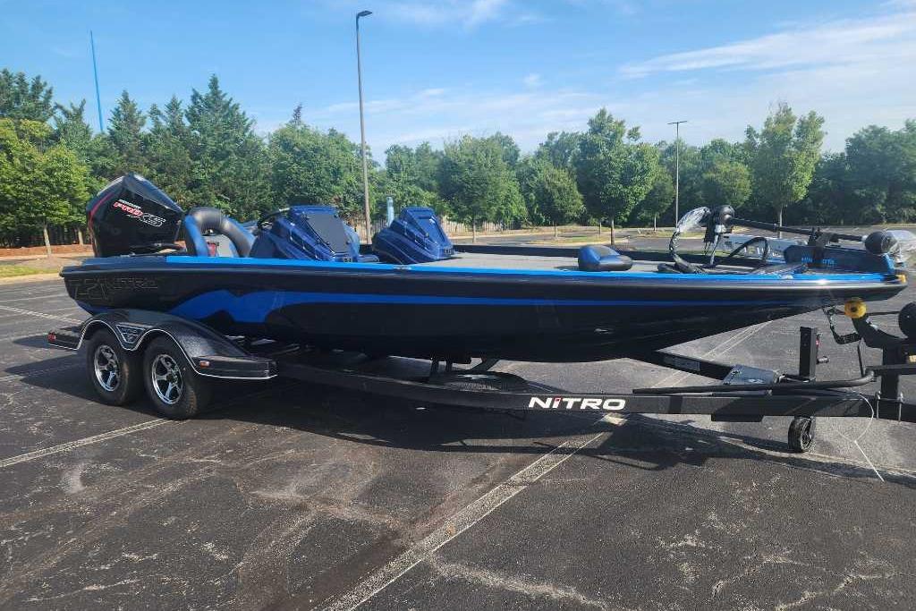 2025 Nitro Z21 XL boat on trailer in parking lot, surrounded by trees.