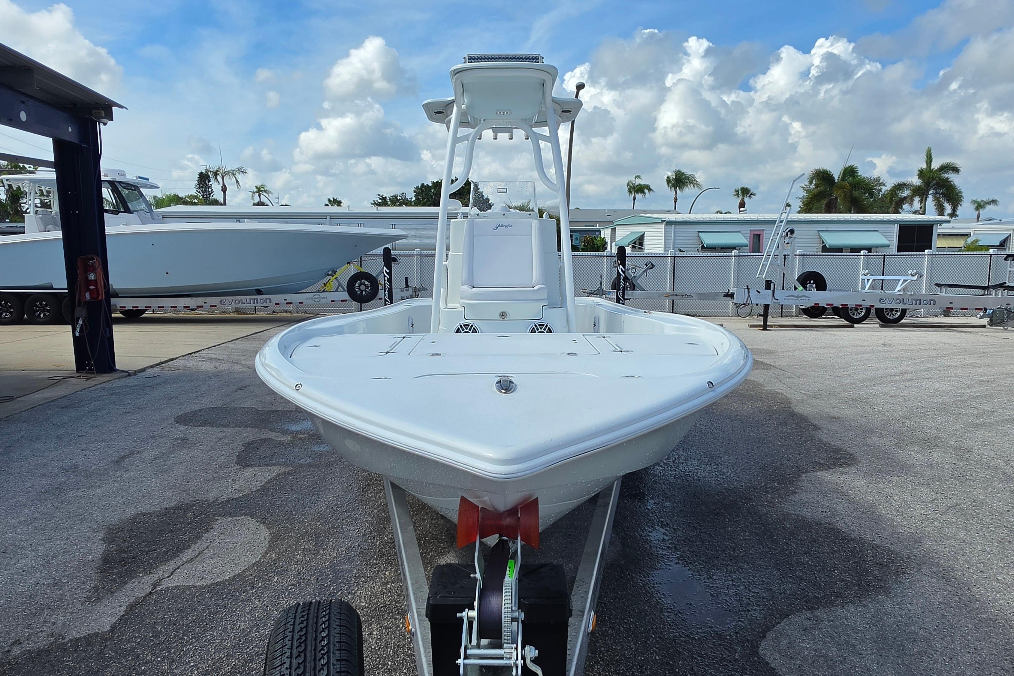 2026 Yellowfin 24 Bay CE boat on trailer, parked outdoors under a cloudy sky.