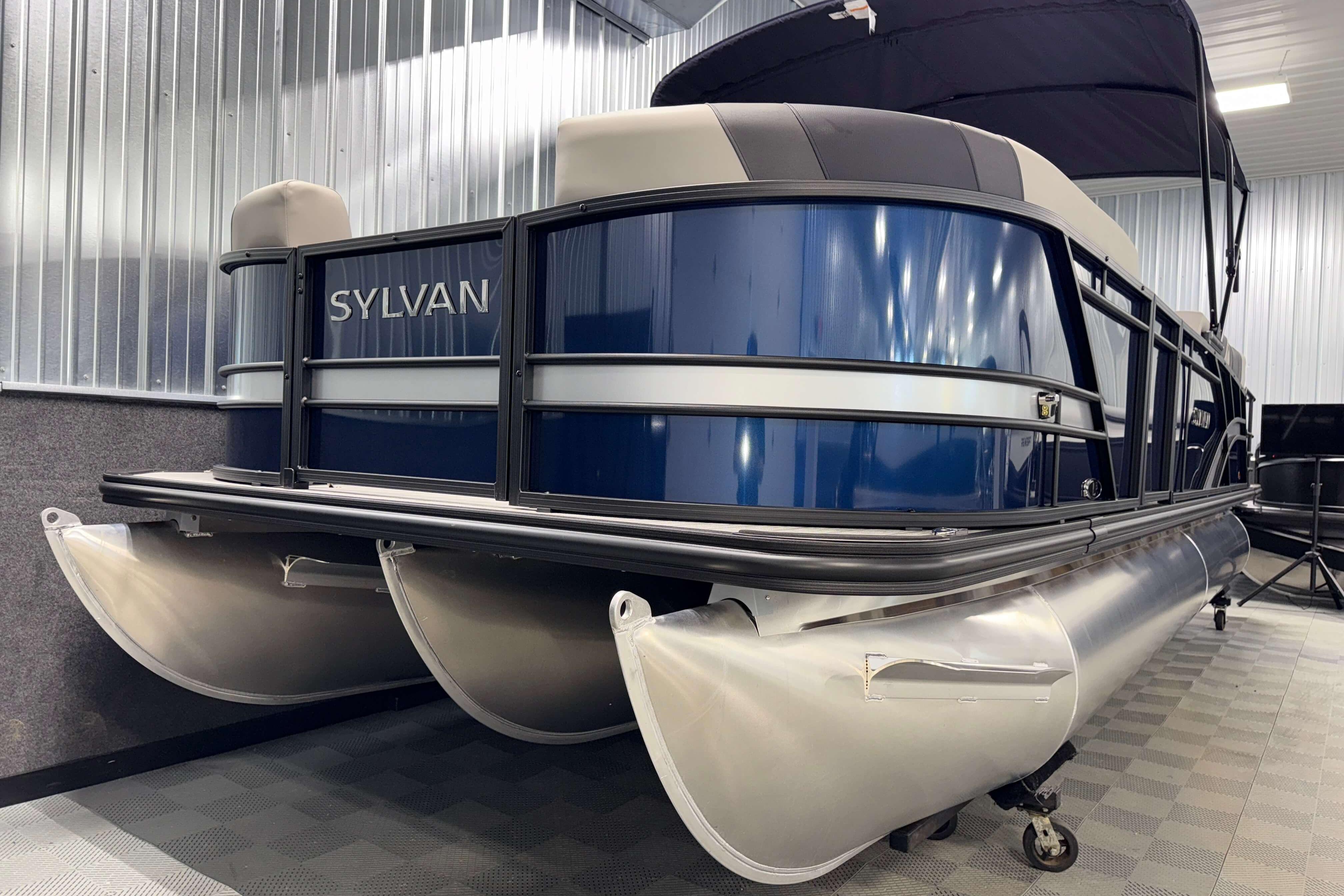 2026 Sylvan L3 SLZ pontoon boat in a showroom, featuring sleek blue and silver design.