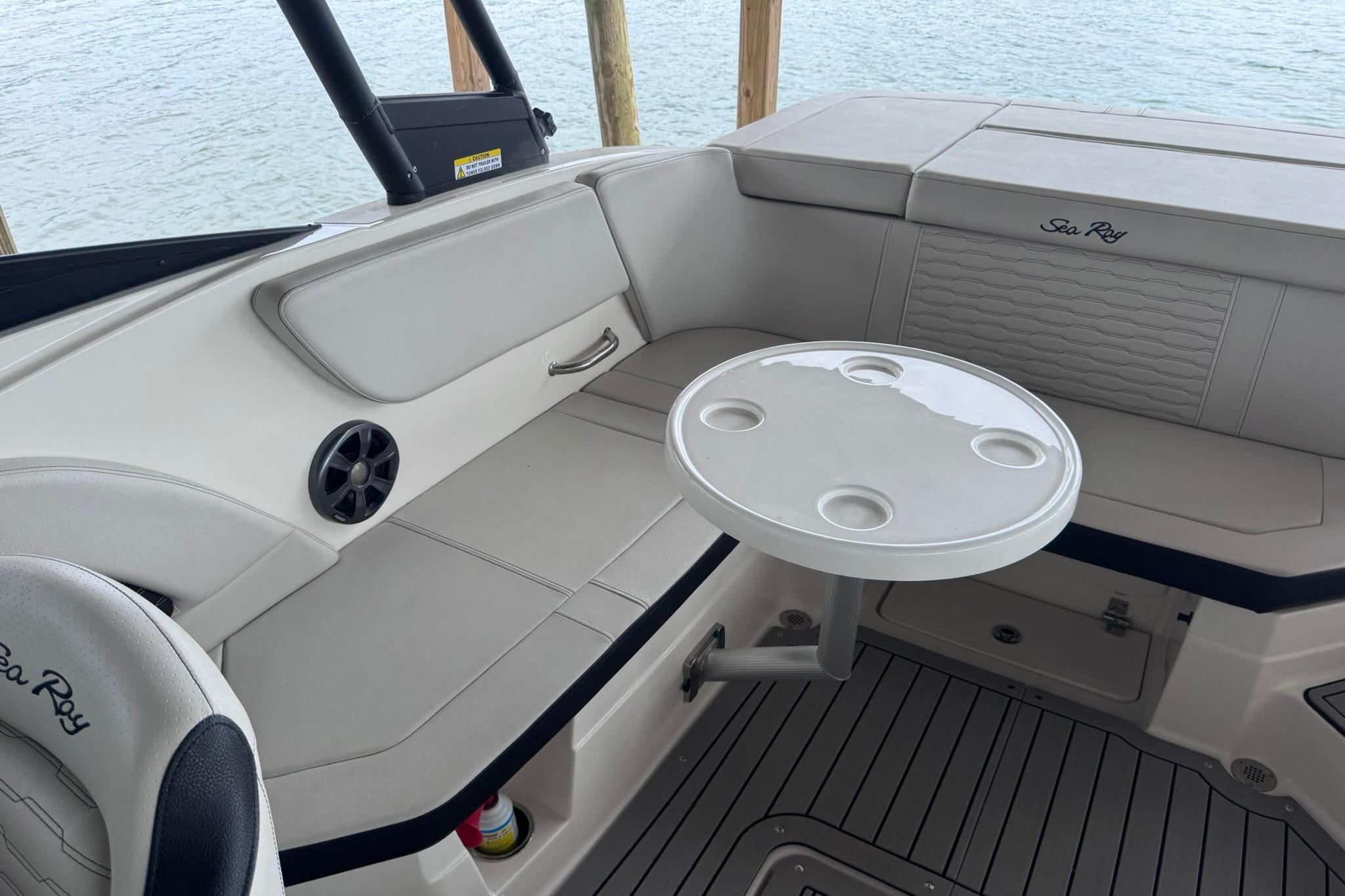 Interior of 2021 Sea Ray SPX 230 boat with seating and round table.