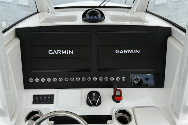 Dashboard of 2025 Regulator 28 boat featuring dual Garmin displays and navigation controls.