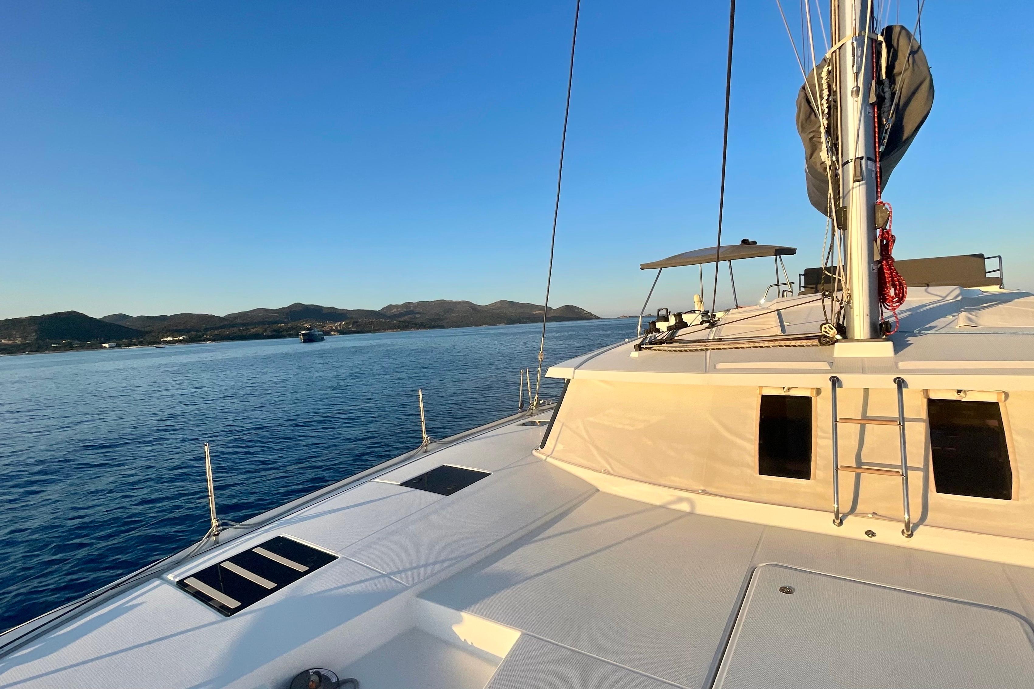 2020 Fountaine Pajot Saona 47 catamaran sailing on calm waters at sunset.