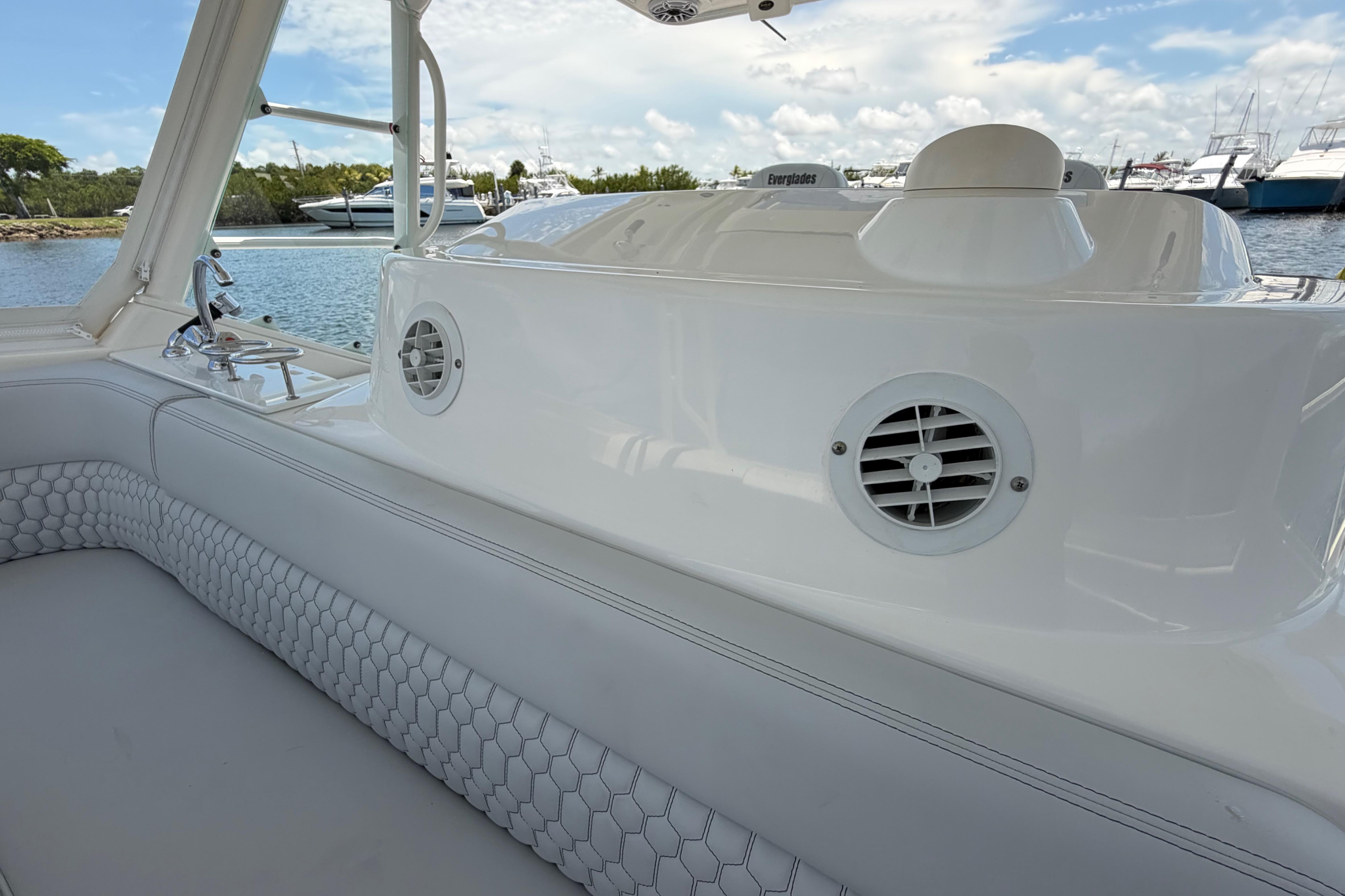 2009 Everglades 350LX boat interior with white seating and speaker, docked by the water.