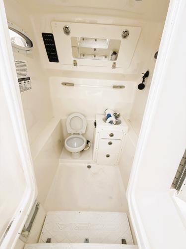 2016 Cobia 296 Center Console boat interior with toilet and storage cabinet.