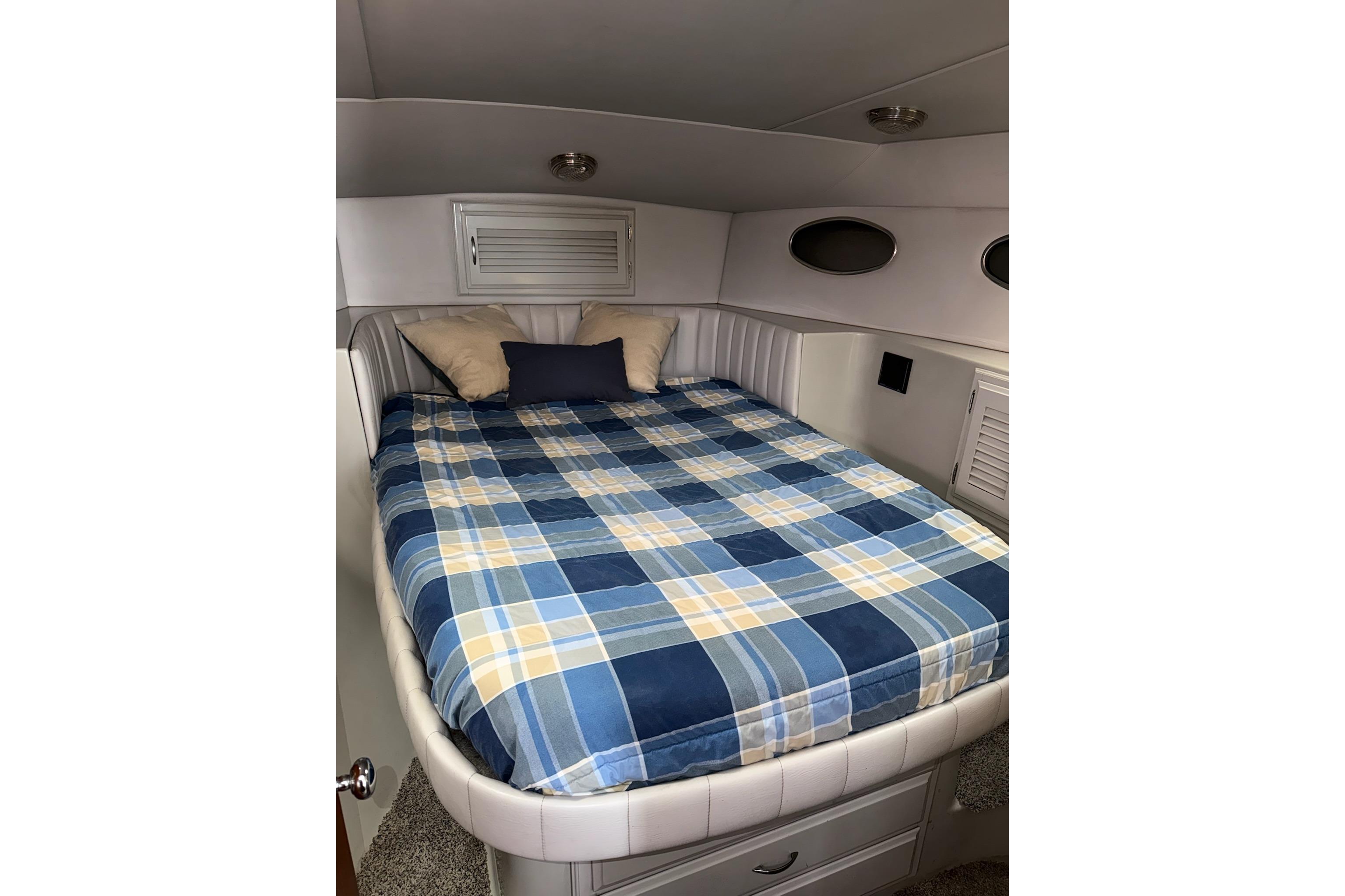 Cozy cabin interior of 1990 Mediterranean Sport Fish boat with plaid bedding.