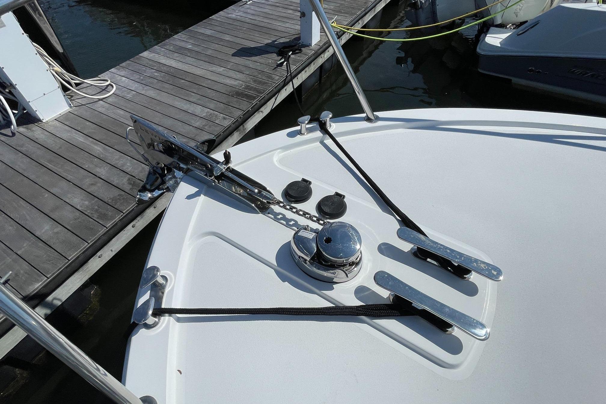 Bow of 2023 MJM 35 boat with anchor and winch at dock.