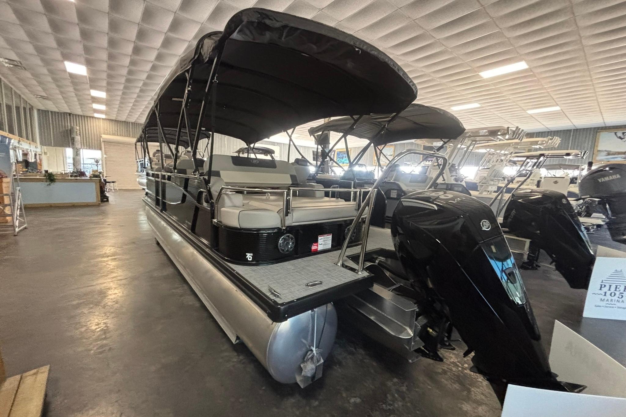 2024 Princecraft Quorum 23 RL pontoon boat displayed indoors with black canopy.