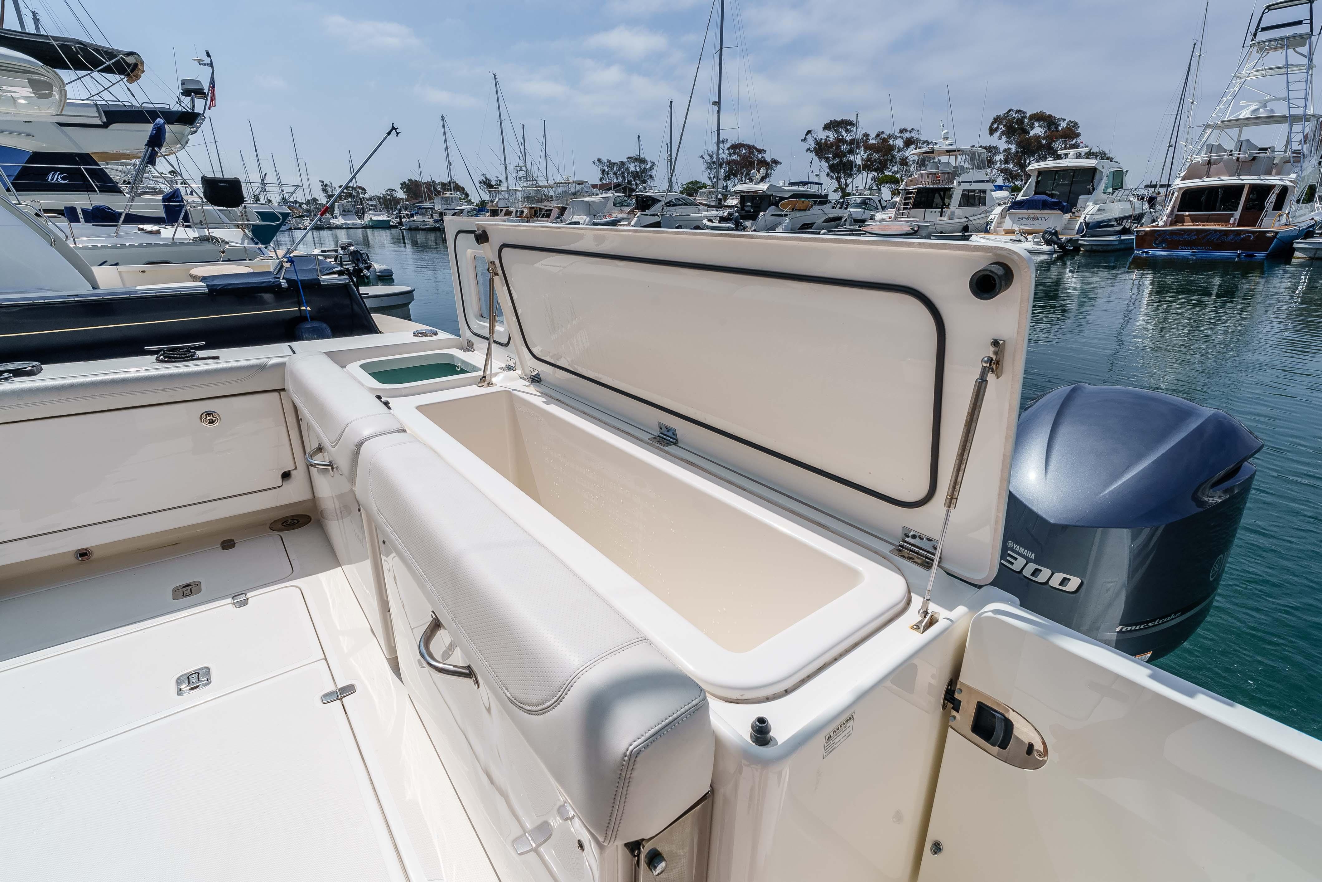 2022 Pursuit OS 385 Offshore boat with open storage compartment at marina.