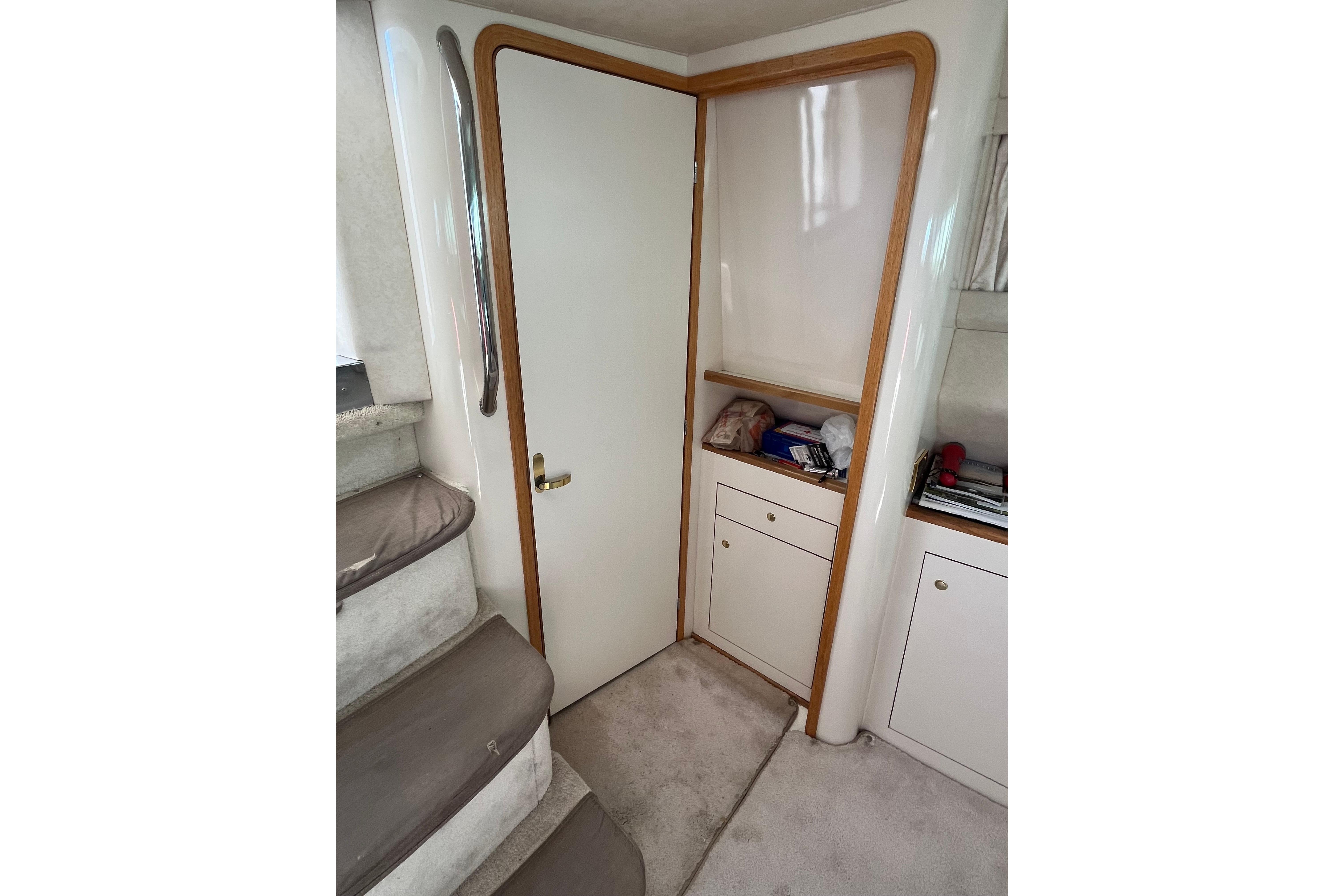 Interior of 1997 Sea Ray 420 Aft Cabin with stairs and storage cabinets.