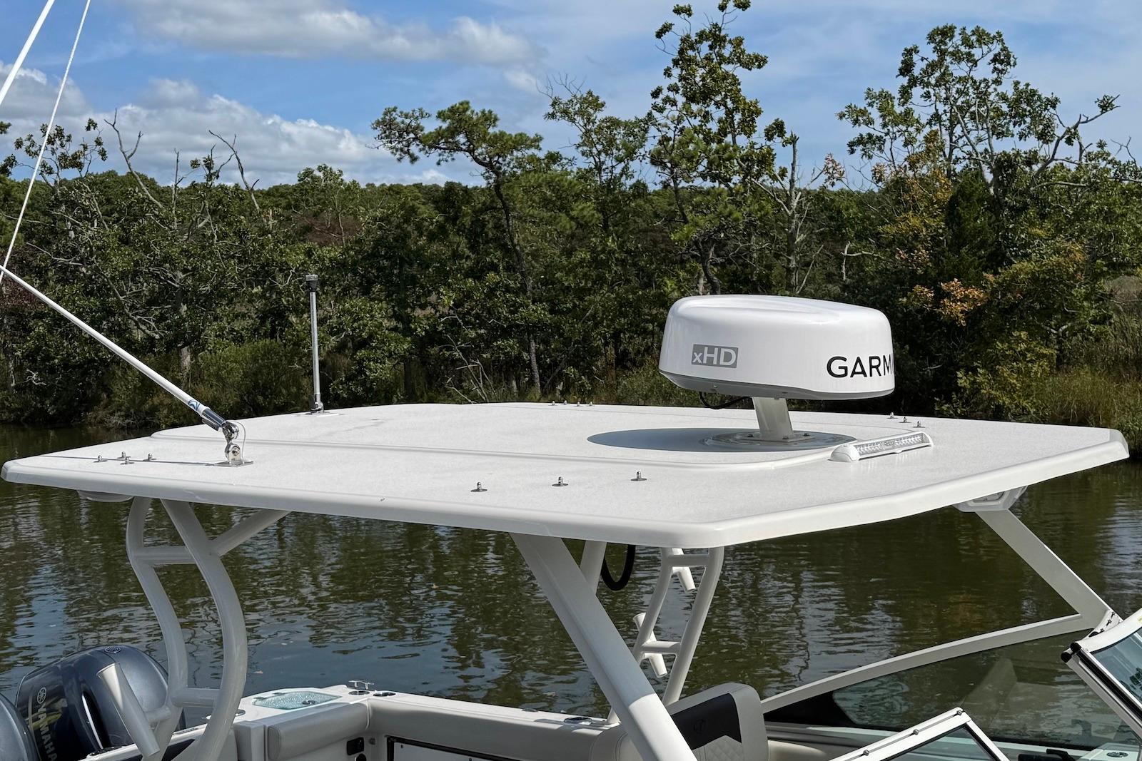 2022 Sailfish 276 DC boat with Garmin radar on top, surrounded by lush greenery.