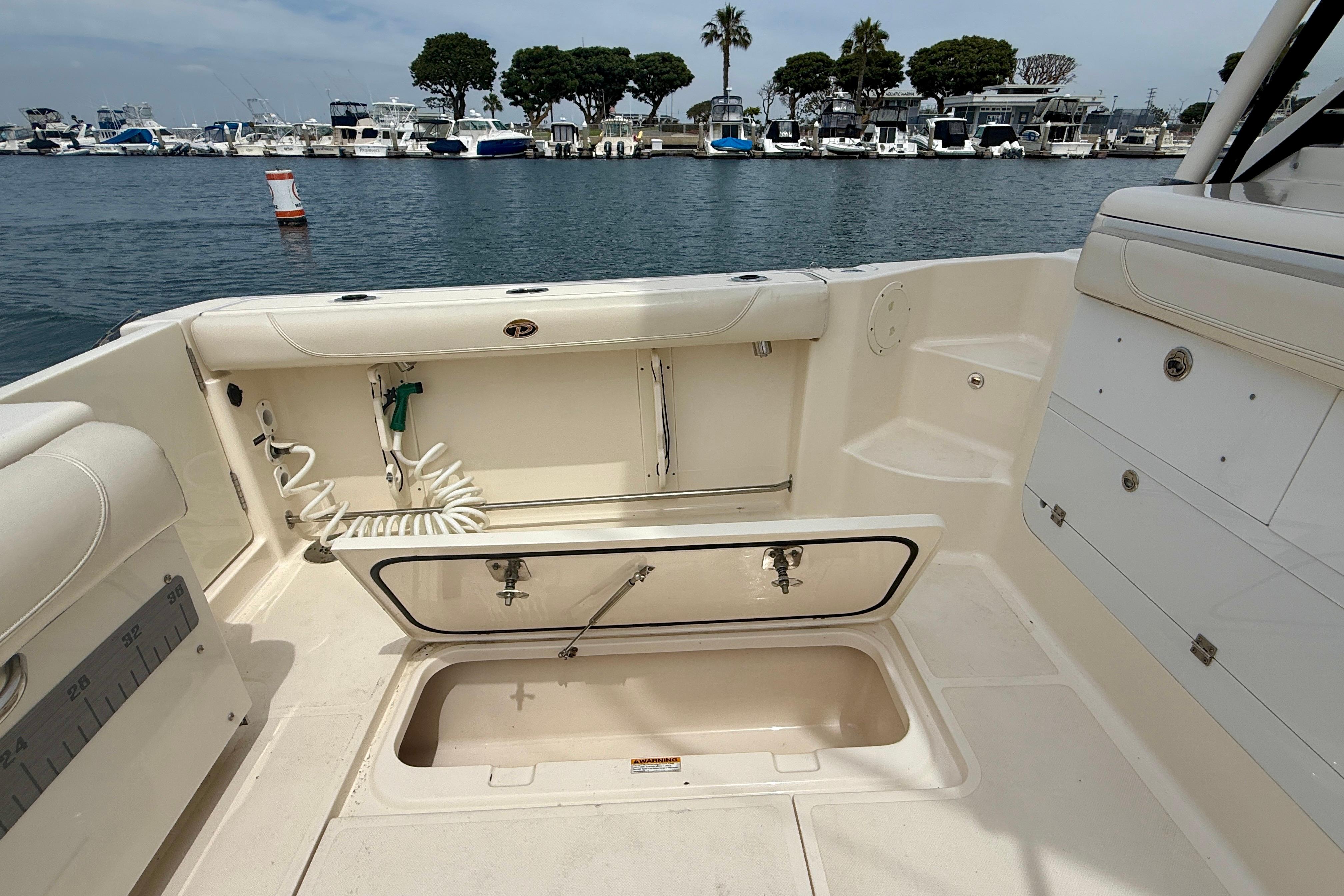 2012 Pursuit OS 345 Offshore boat interior with open storage compartment, docked at marina.