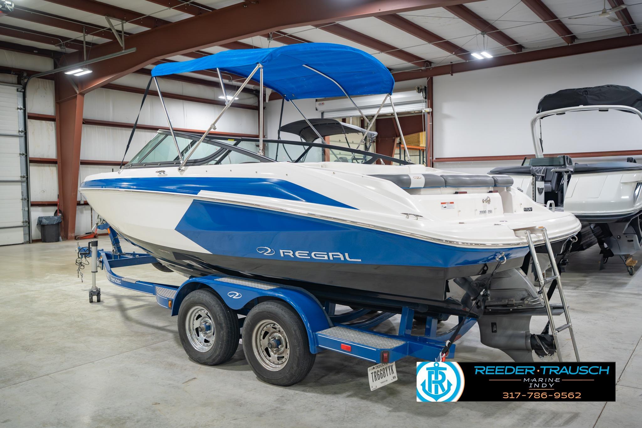2015 Regal 2000 ESX Bowrider boat with blue accents on a trailer in a showroom.