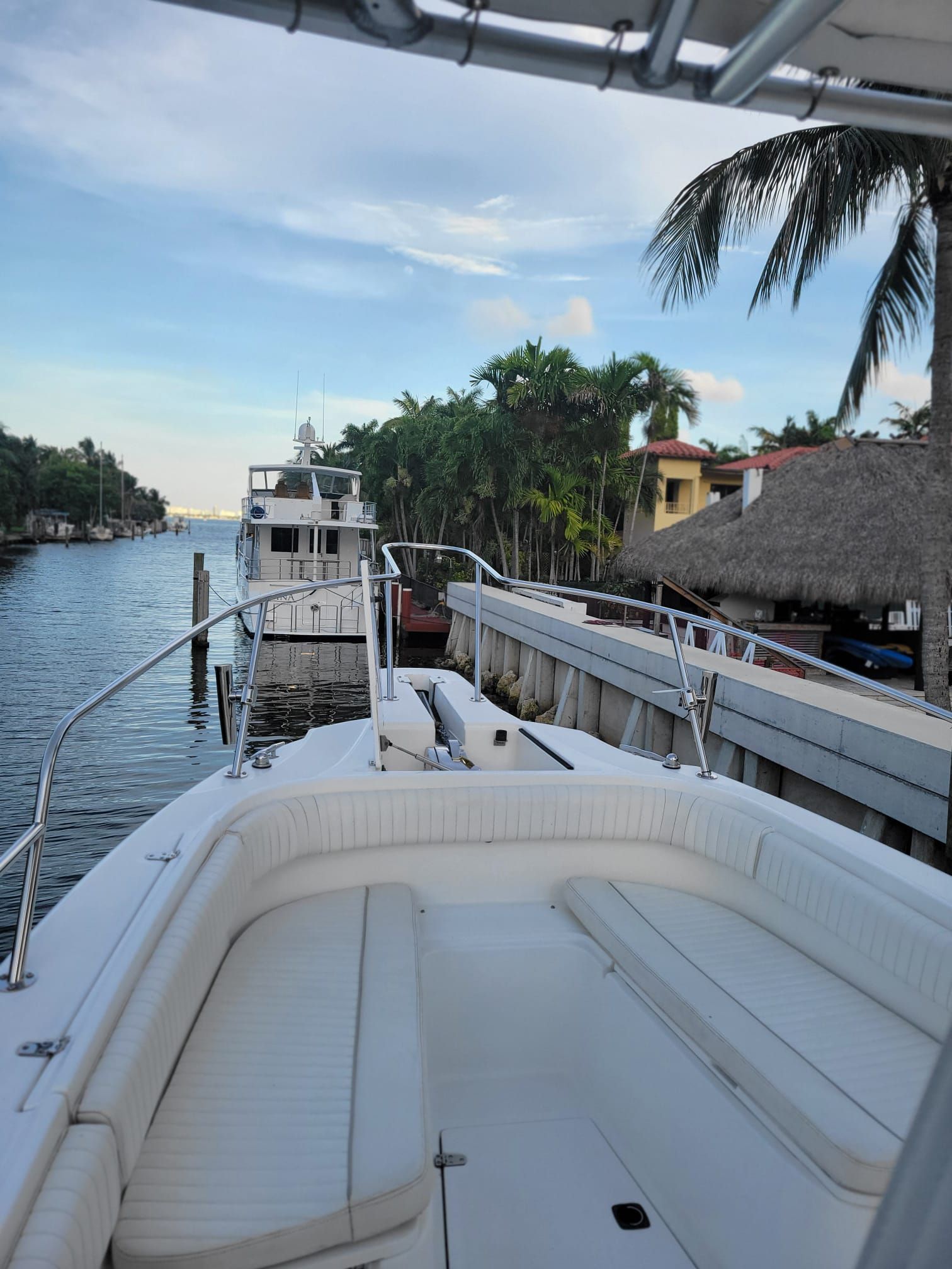 Boston Whaler 26 Outrage 2001 by the water with palm trees.