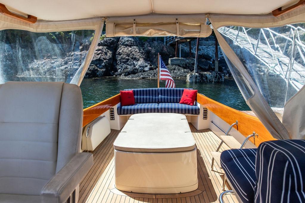 Interior of 2000 Hinckley Picnic Boat 36 Classic with striped seating and American flag.