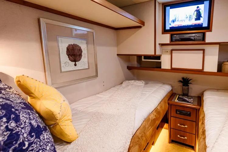 Luxurious cabin interior of 2000 Pacific Mariner 65 Motoryacht with twin beds and TV.