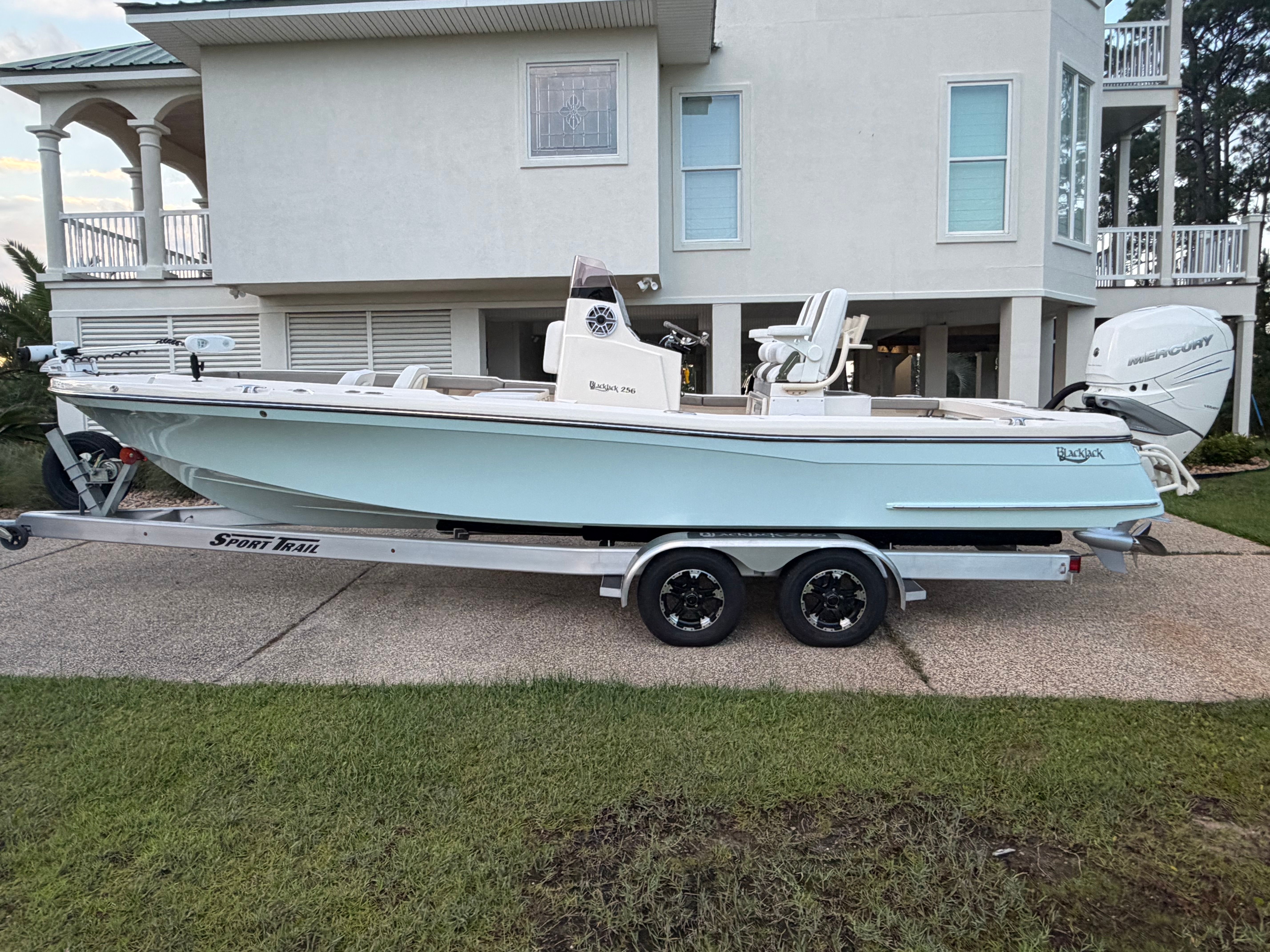 2022 BlackJack 256 Coastal boat on trailer in front of house.