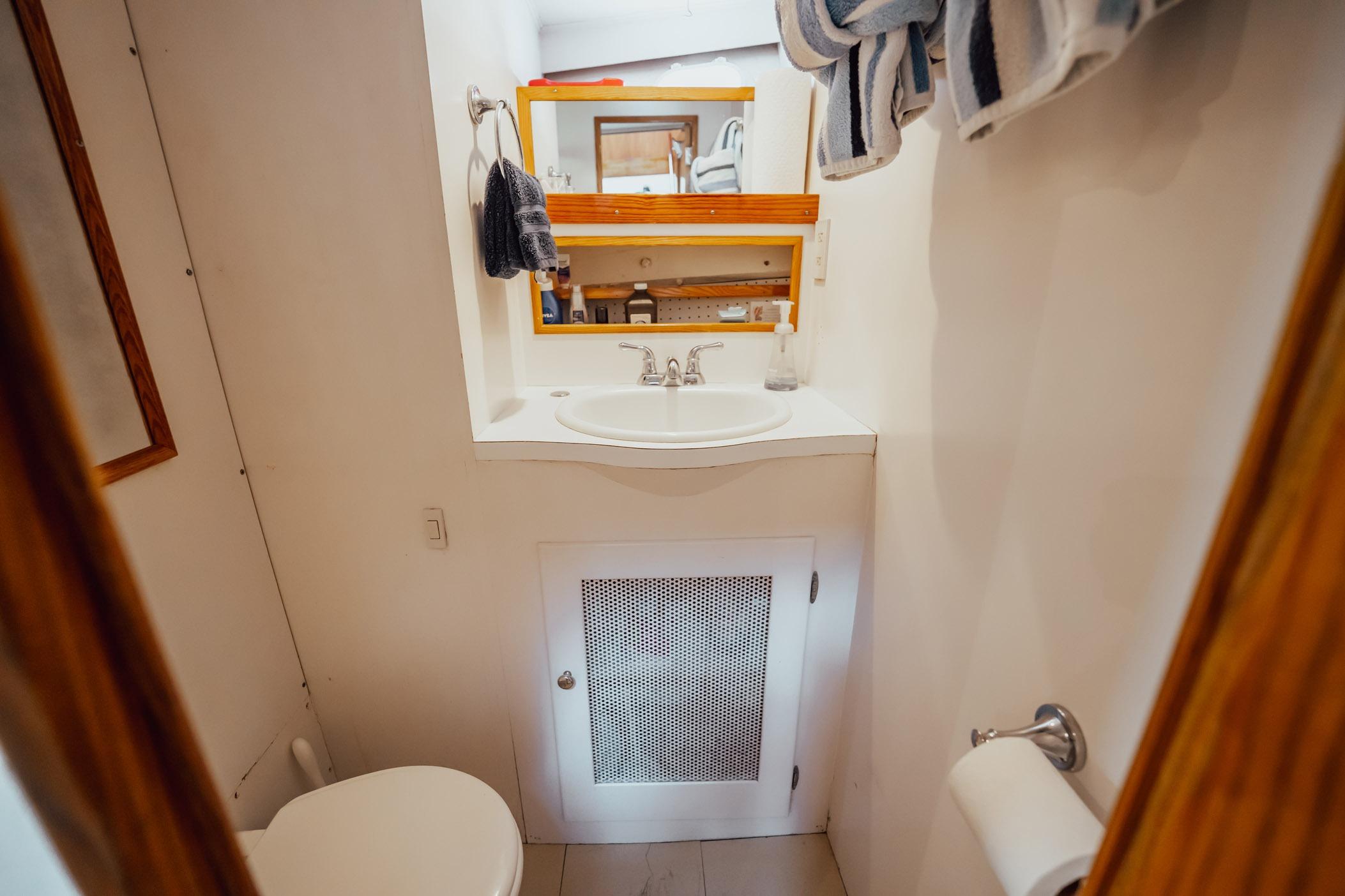 Bathroom interior of 1972 Trumpy 72 Motor Yacht with sink and mirror.