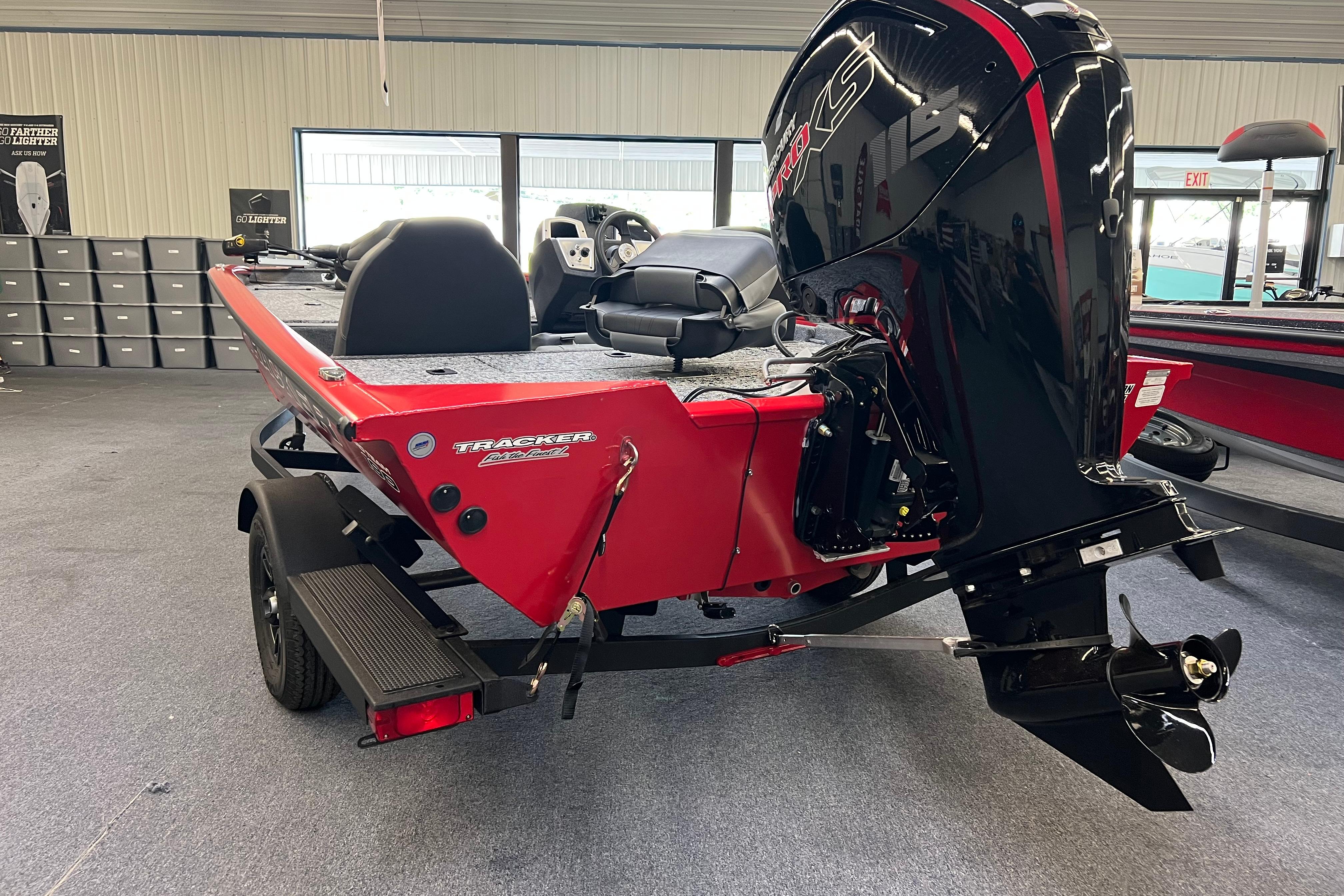 2026 Tracker Pro Team 190 boat with powerful outboard motor in showroom.