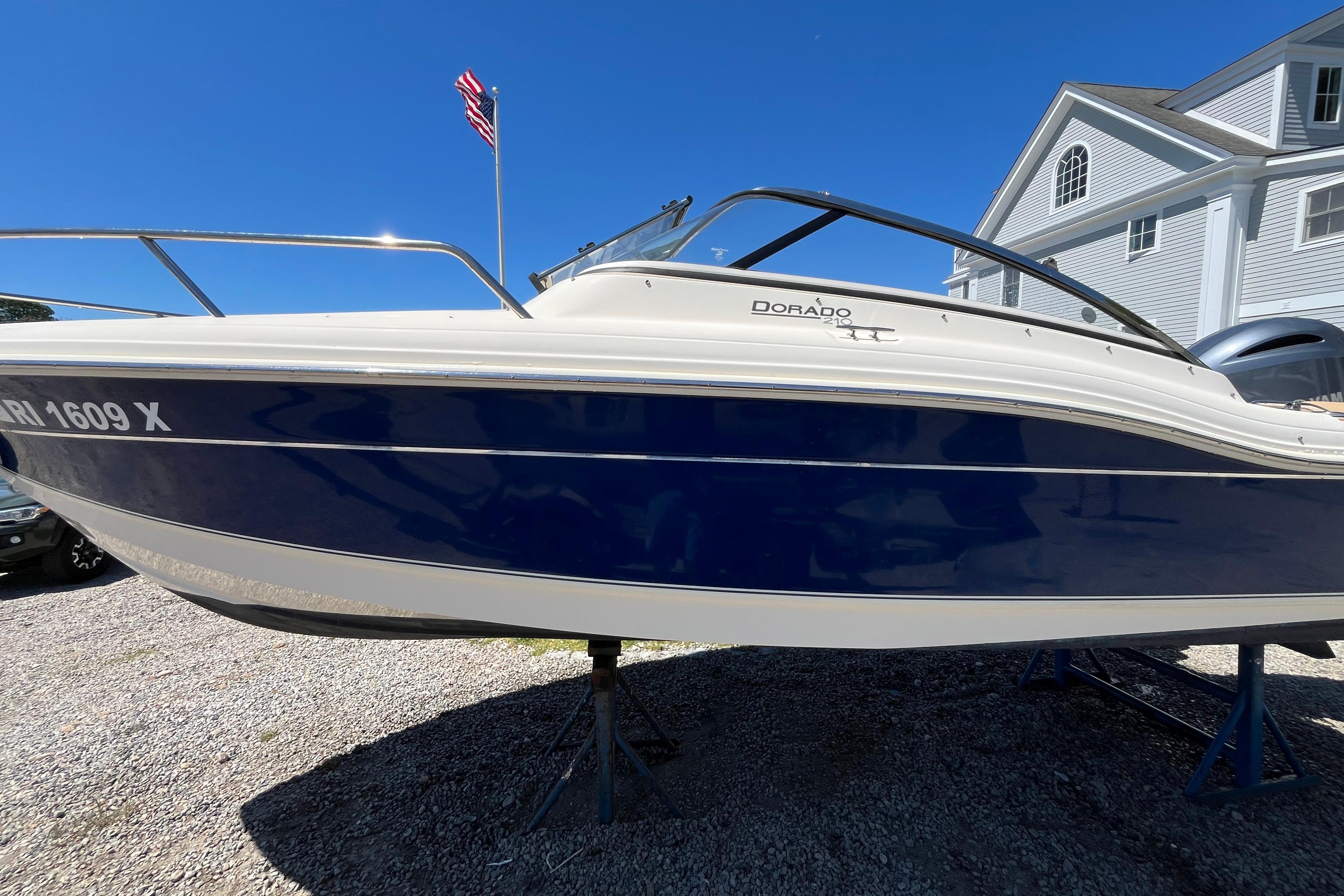 2017 Scout 210 Dorado boat on display, blue and white hull, sunny day.