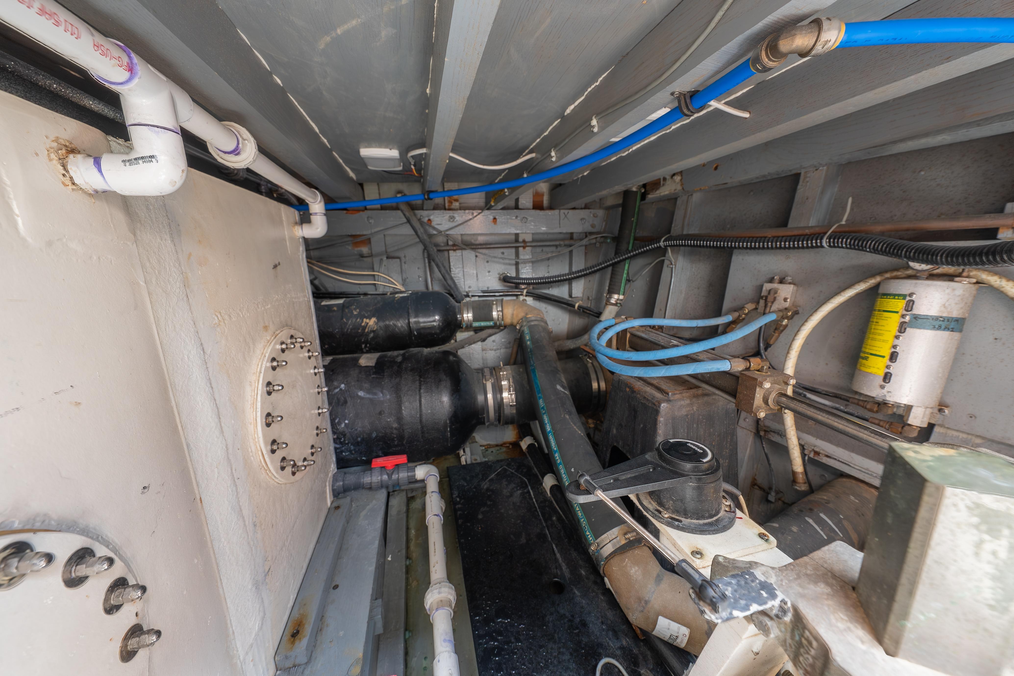 Engine room of a 1963 Trumpy Classic boat, featuring pipes and mechanical components.