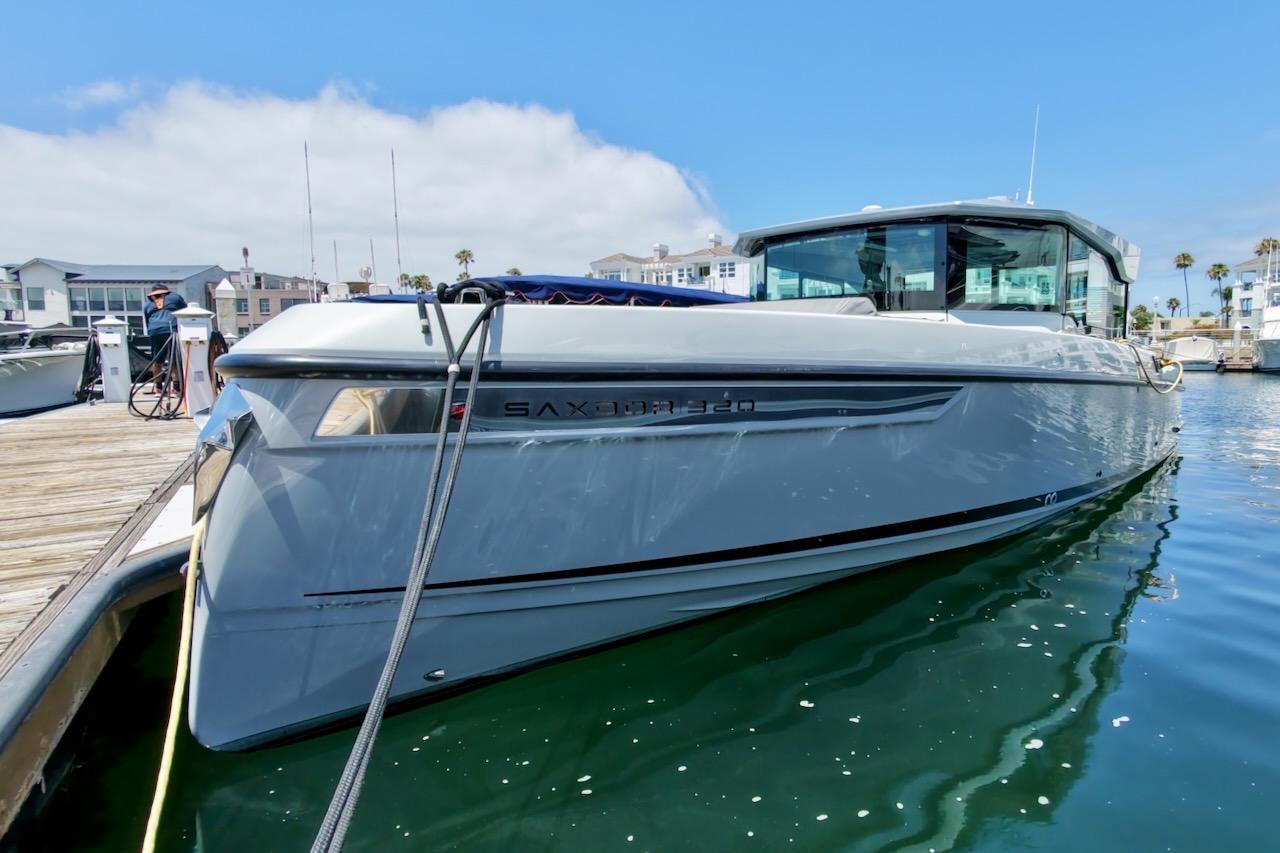 2024 Saxdor 320 GTC boat docked at marina under clear blue sky.