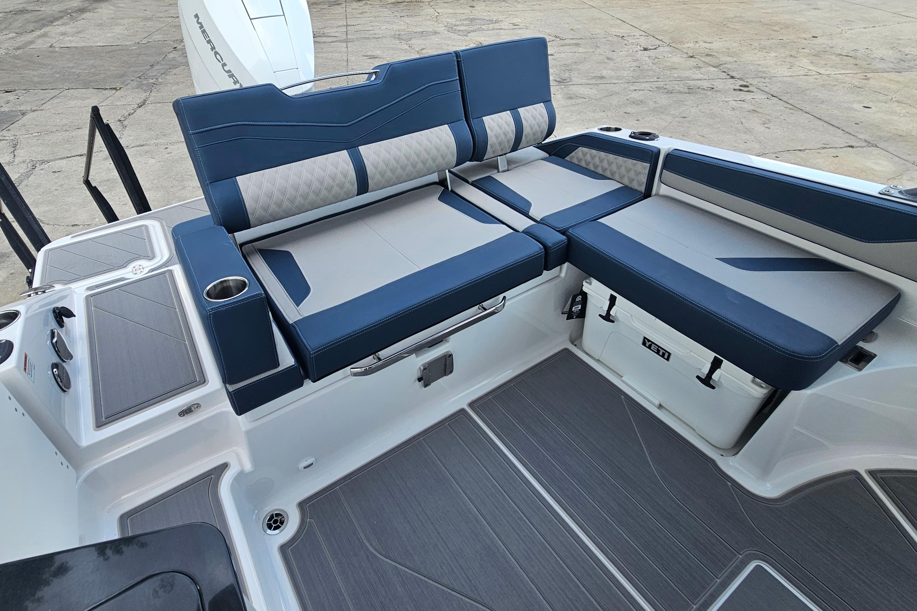 2026 Monterey Elite 27 OB boat interior with blue and gray seating and cup holders.