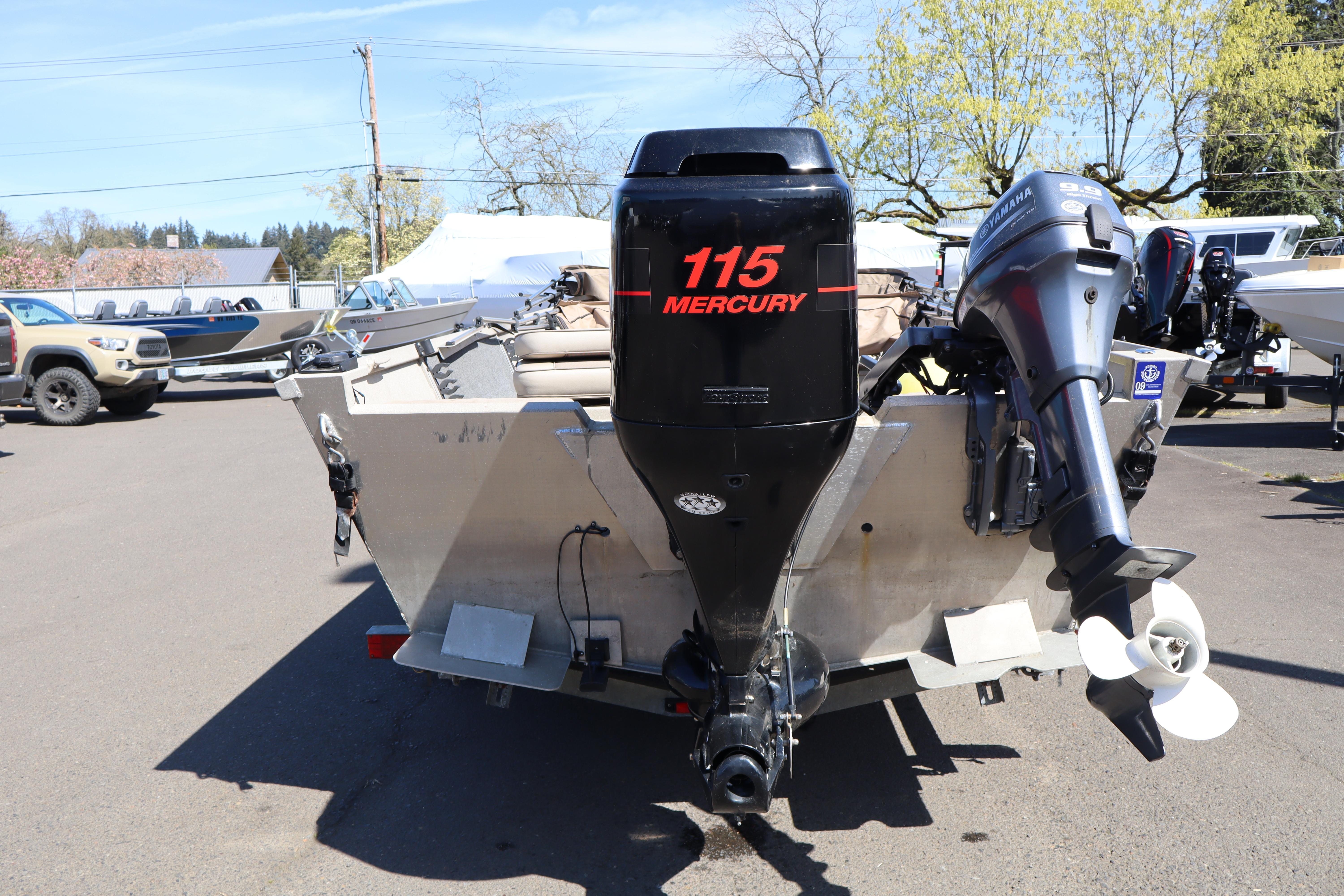 2002 Alumaweld SUPER VEE LS boat with Mercury 115 outboard motor in parking lot.