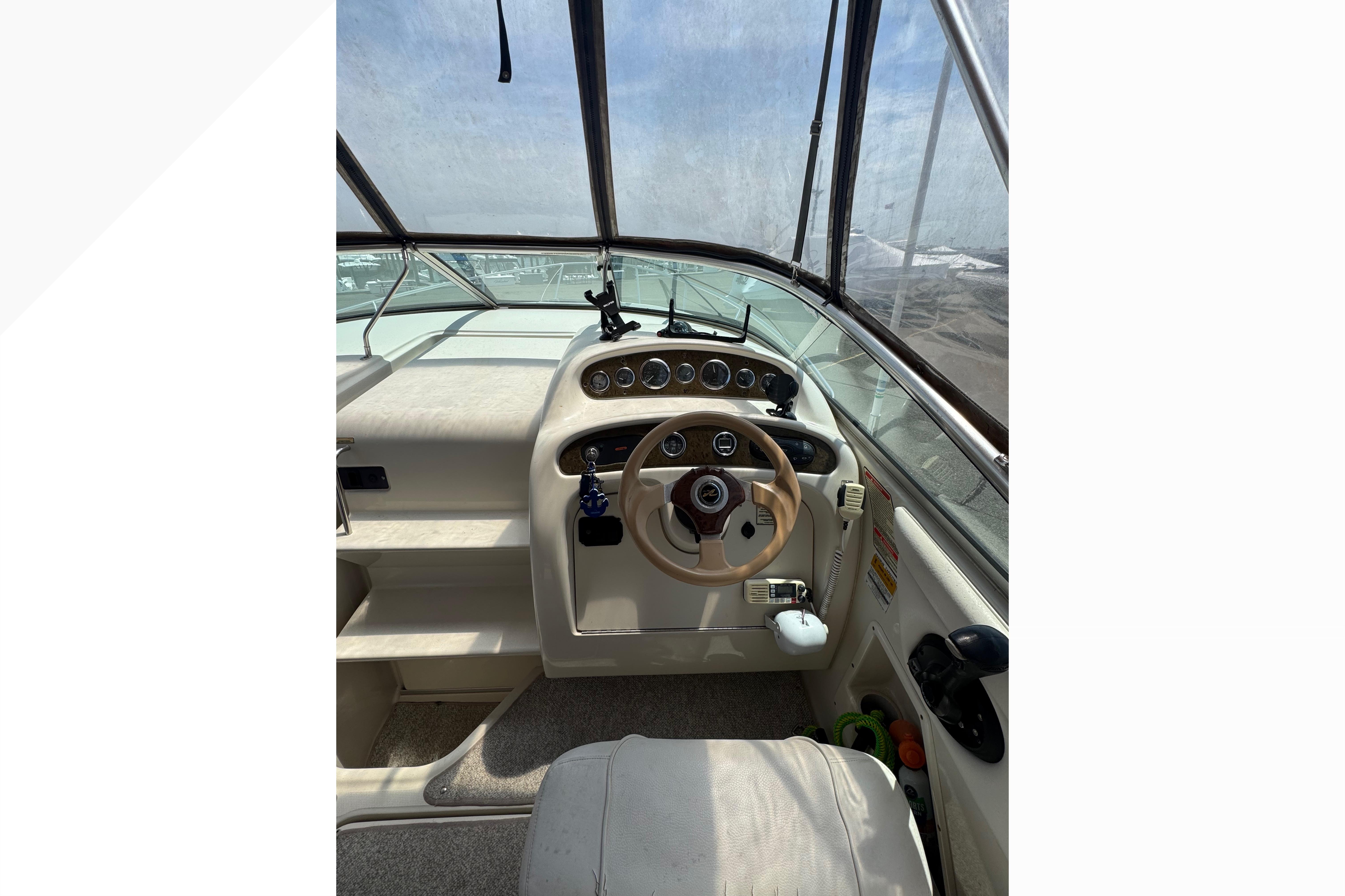 Cockpit view of 2001 Sea Ray 245 Weekender boat with steering wheel and dashboard.