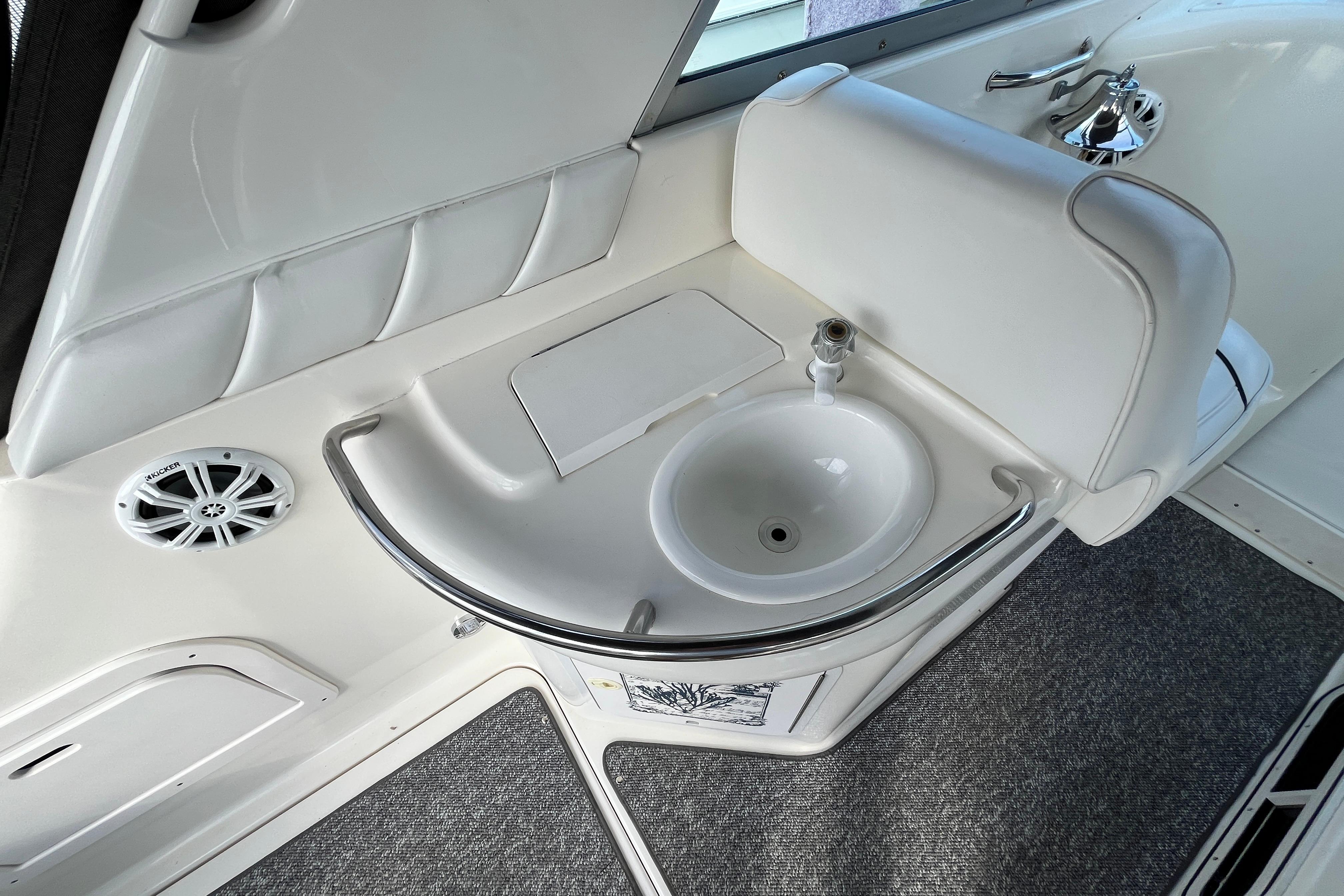 1995 Sea Ray Sundancer 330 interior with sink and speaker, featuring white upholstery.