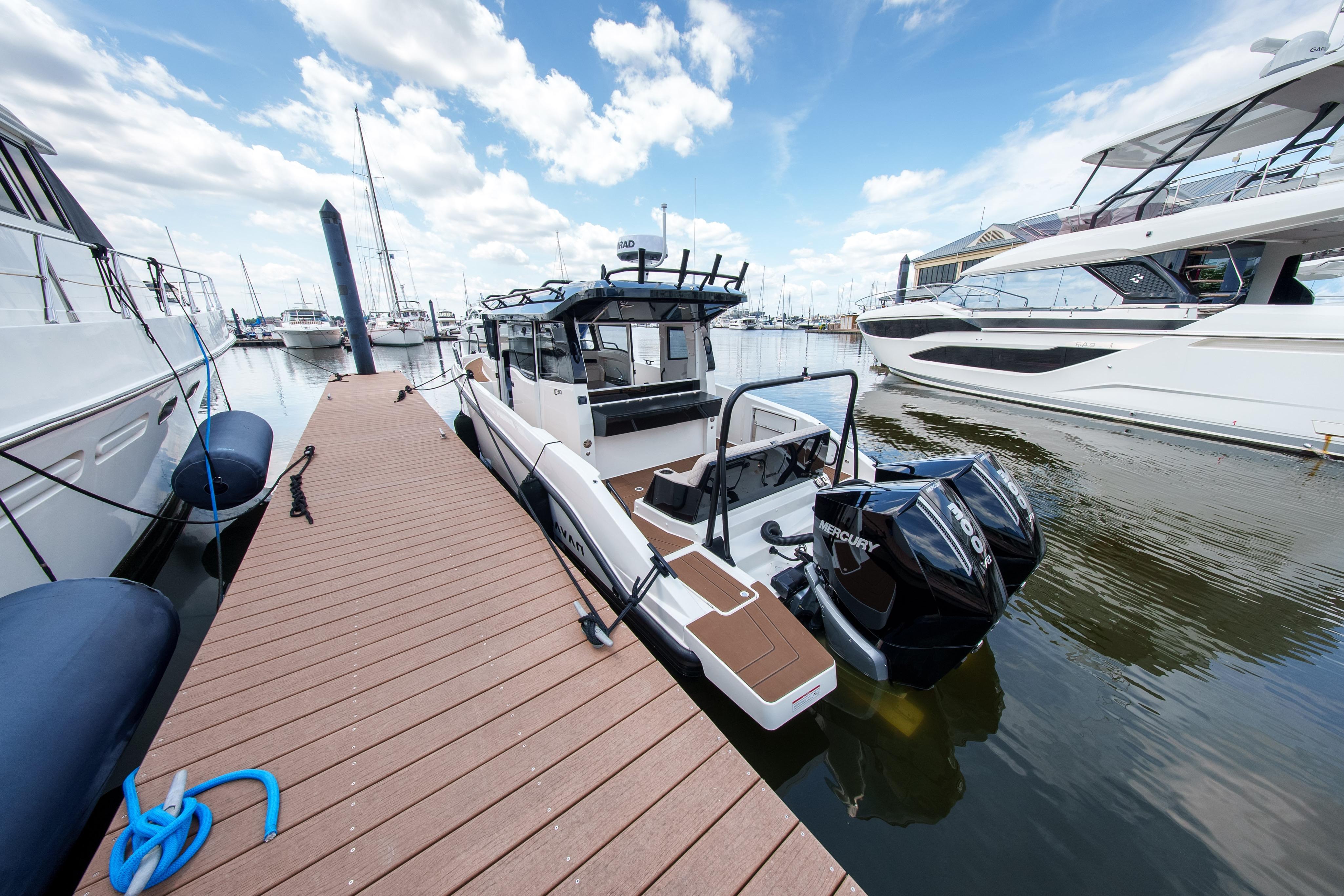 Modern 2026 Navan C30 boat docked at marina, featuring dual Mercury engines.