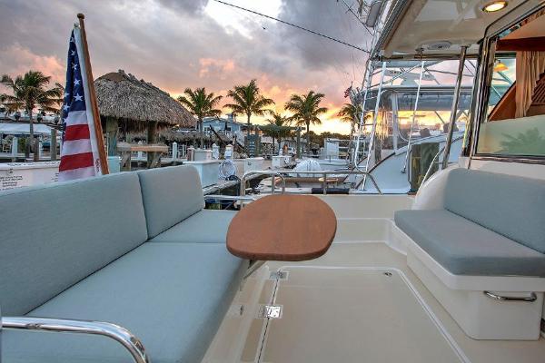 The image shows the aft deck of a 2027 Sabre 38 Salon Express with seating and a table.