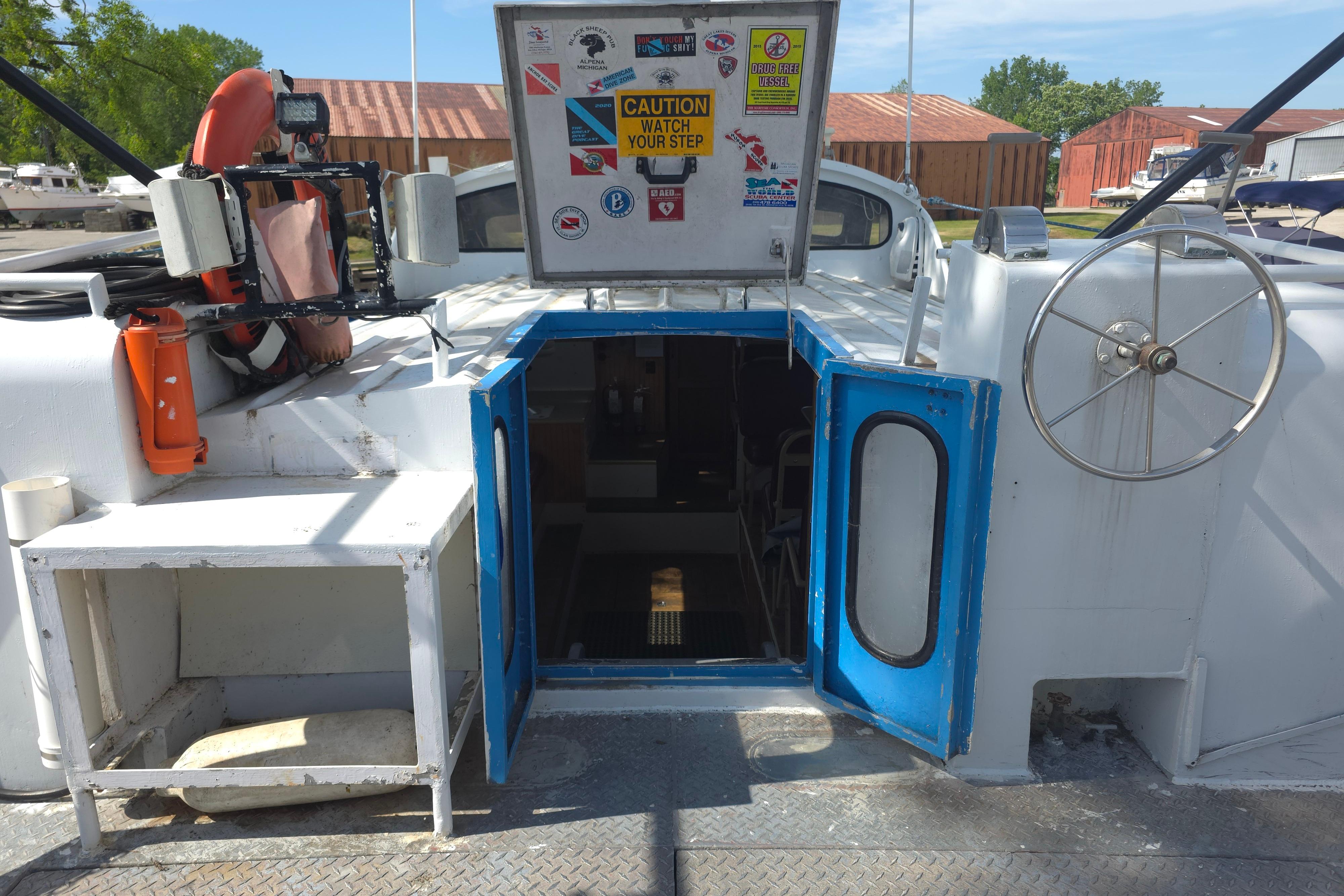 1974 Breaux's Bay Craft Passenger boat with open hatch, safety equipment, and caution signage.