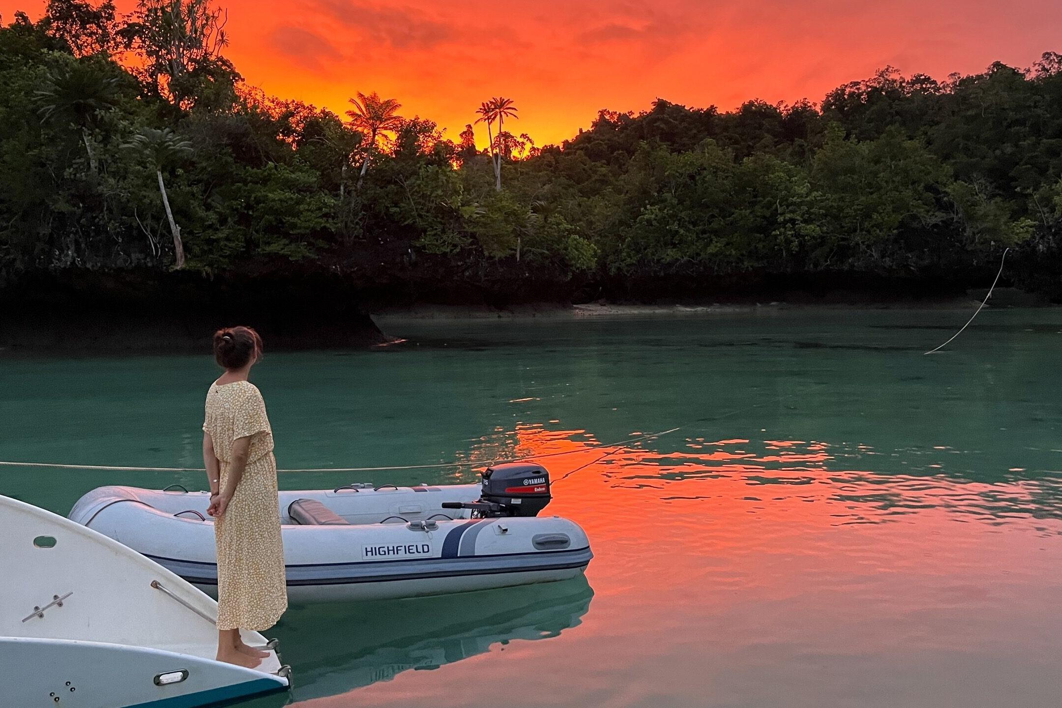 Woman stands beside Highfield UltraLite 290LT boat at sunset.