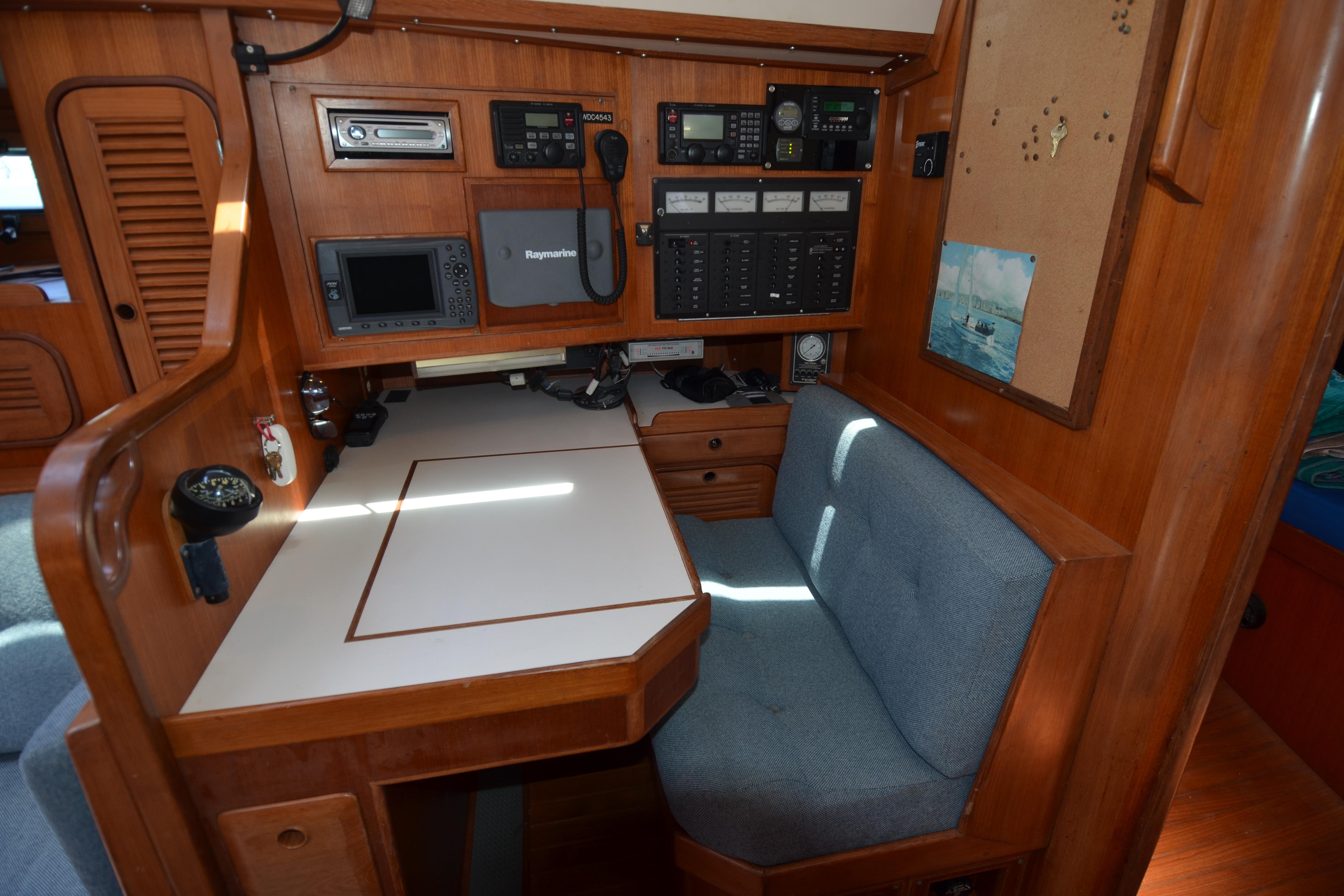Navigation station inside 1987 Norseman 400 sailboat with control panels and seating.