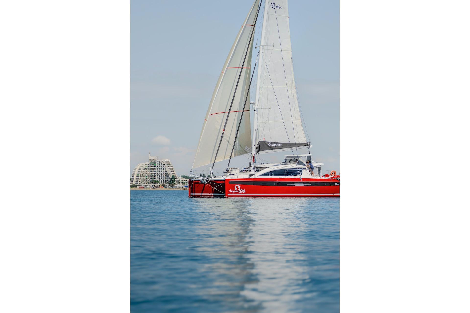 Red Privilege Signature 510 yacht sailing on calm waters, 2025 model.