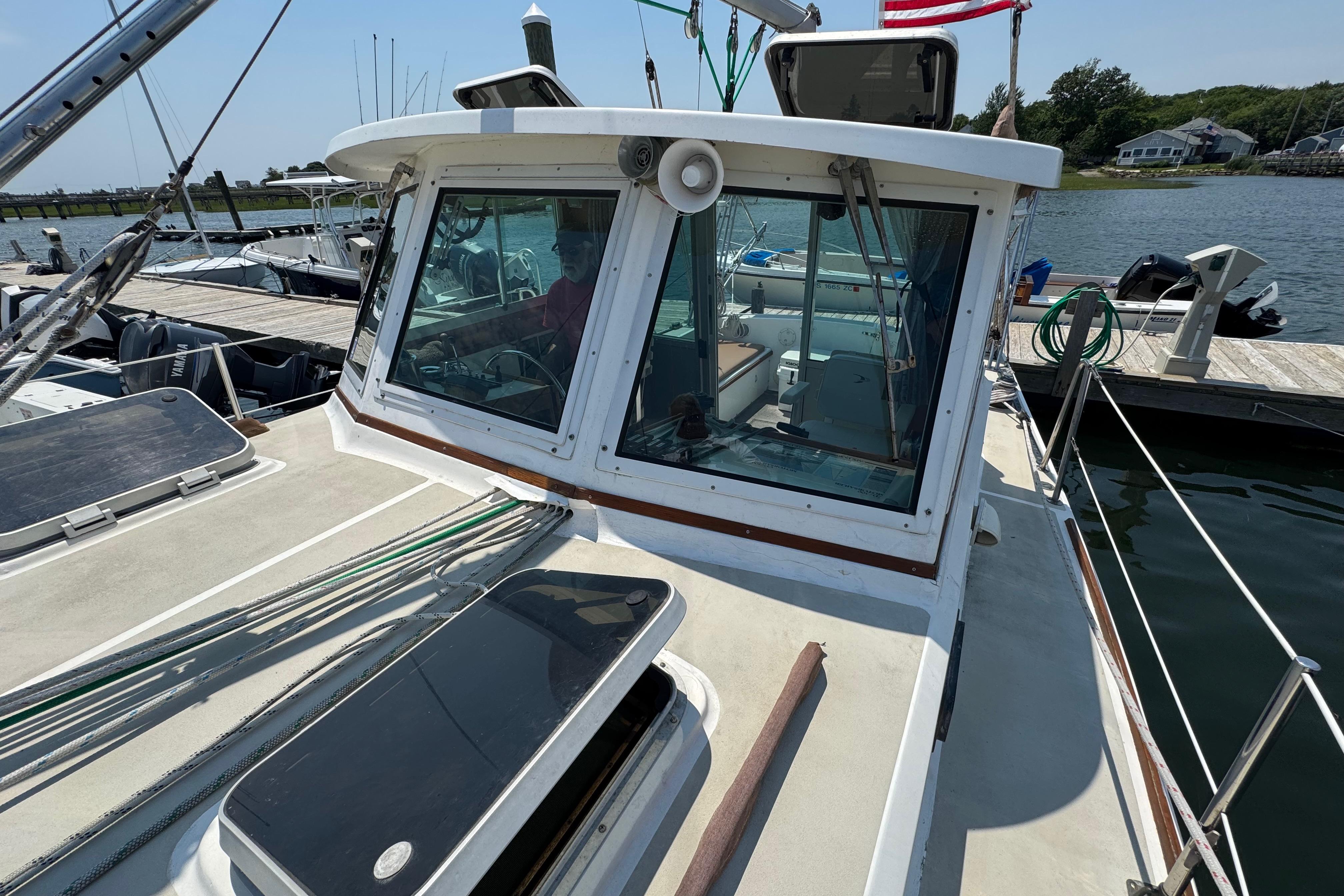 1989 Cape Dory 30 Motorsailer docked, showcasing cabin windows and deck details.
