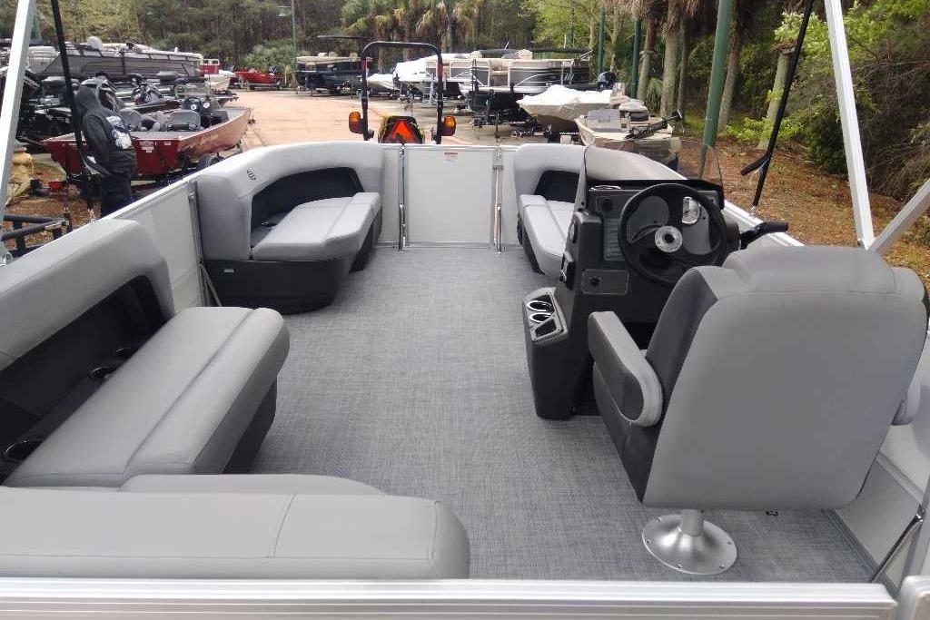 2026 Sun Tracker Party Barge 16 DLX interior with gray seating and steering console.