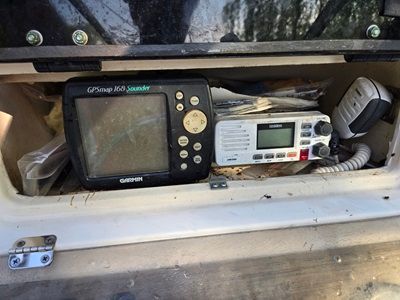 A GPS chartplotter and a radio are mounted in a boat's storage compartment.