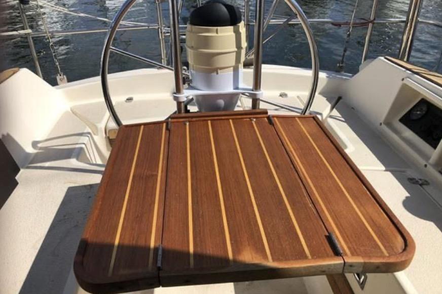 Cockpit of 1991 Caliber 33 sailboat with wooden table and steering wheel.