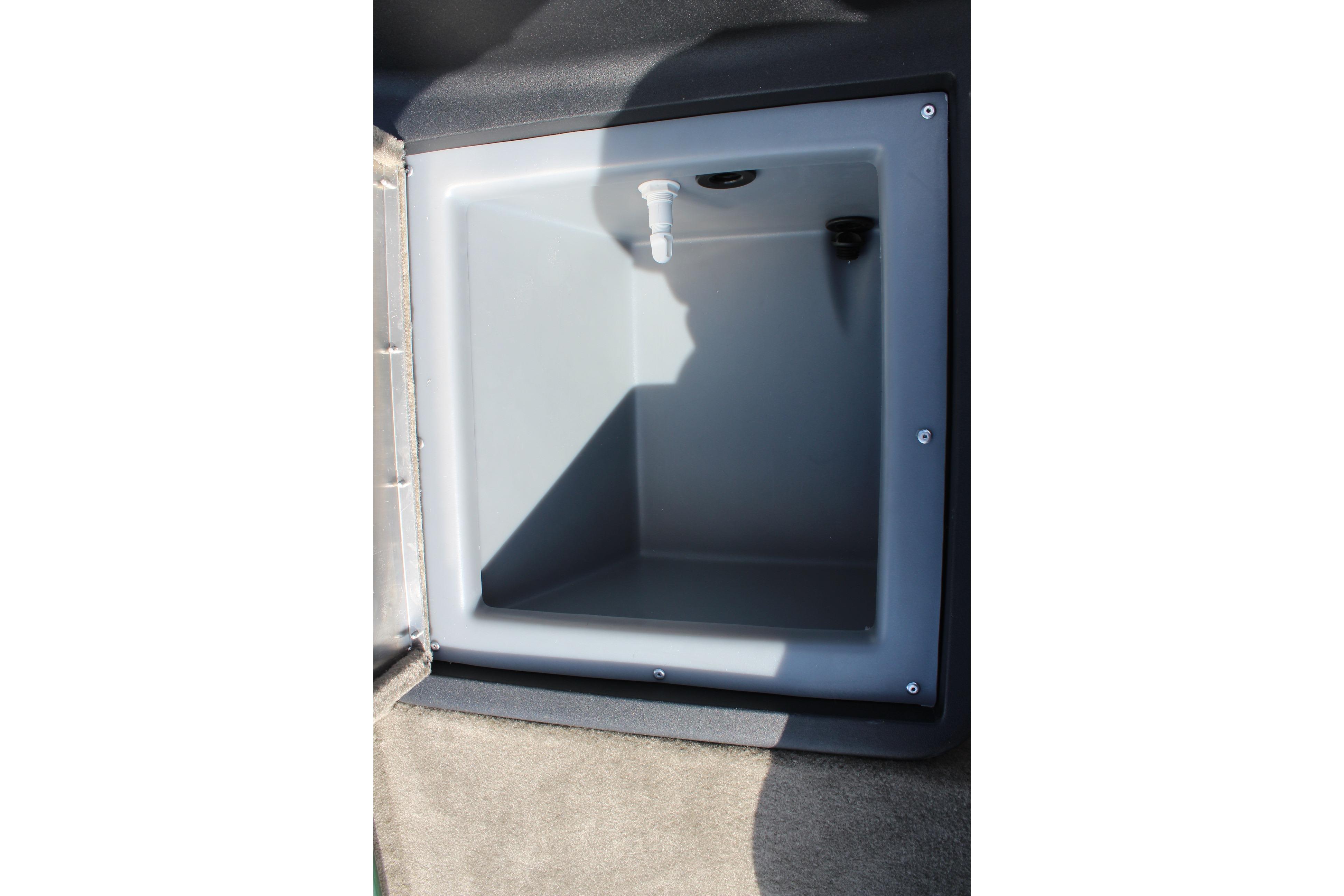 2026 Tracker Bass Tracker Classic Limited storage compartment, open and empty, with a drain plug.