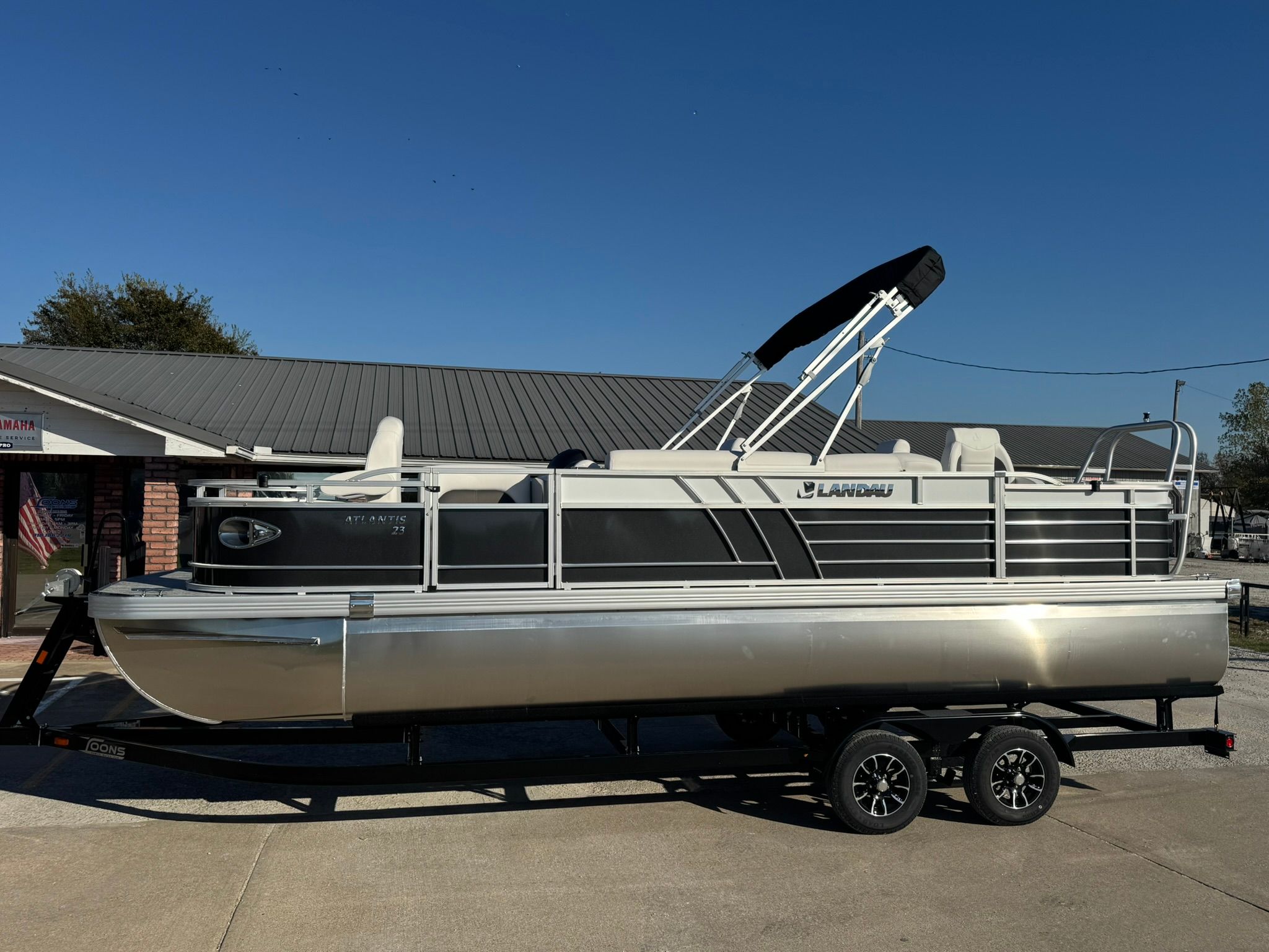 2026 Landau 23C Atlantis pontoon boat on trailer, side view.