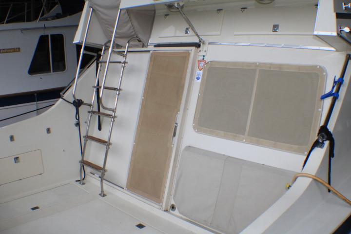 1988 Tollycraft 30 Sport Cruiser deck with ladder and covered windows.