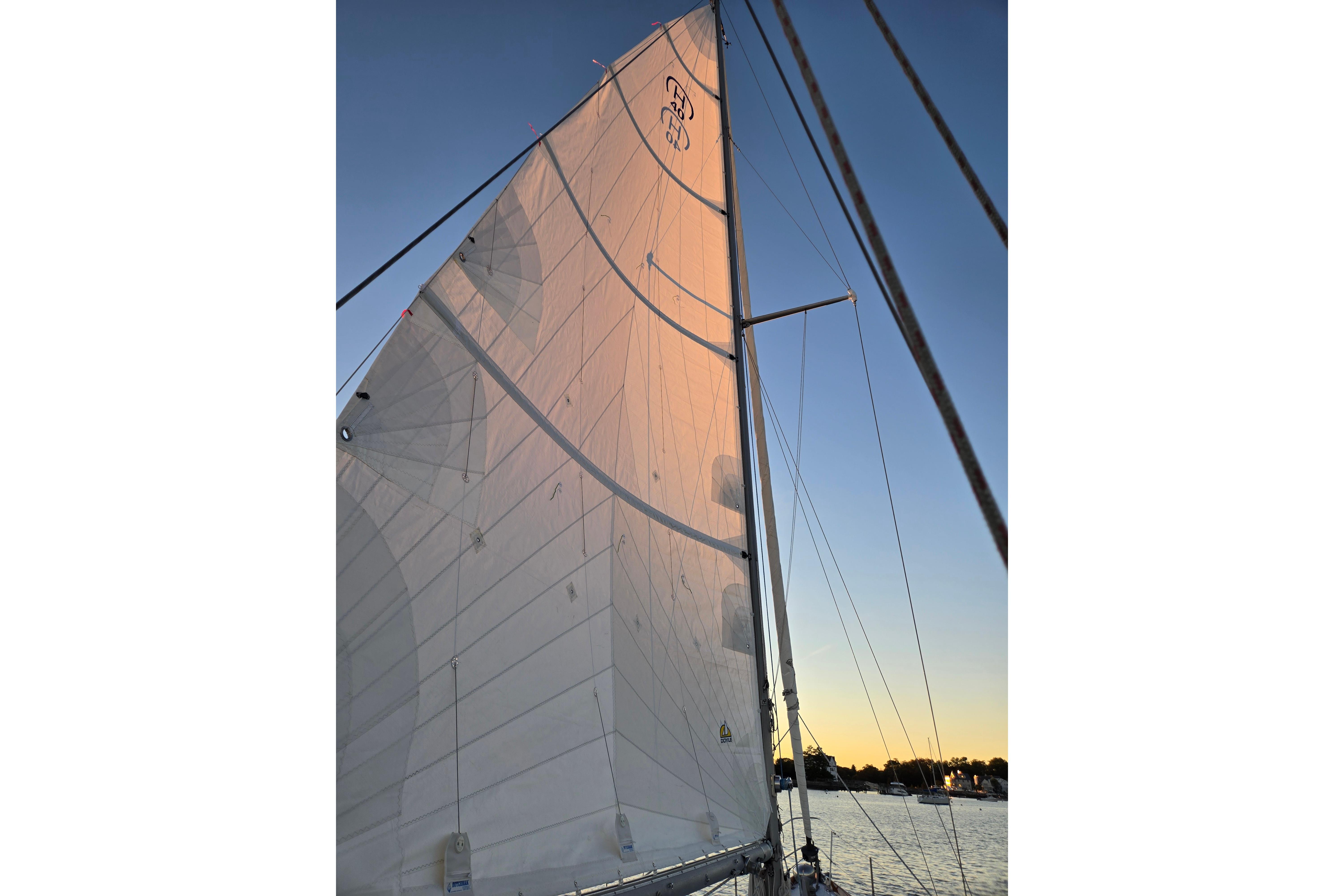 Sailing at sunset on a 1970 Hinckley Bermuda 40, showcasing its majestic sails.