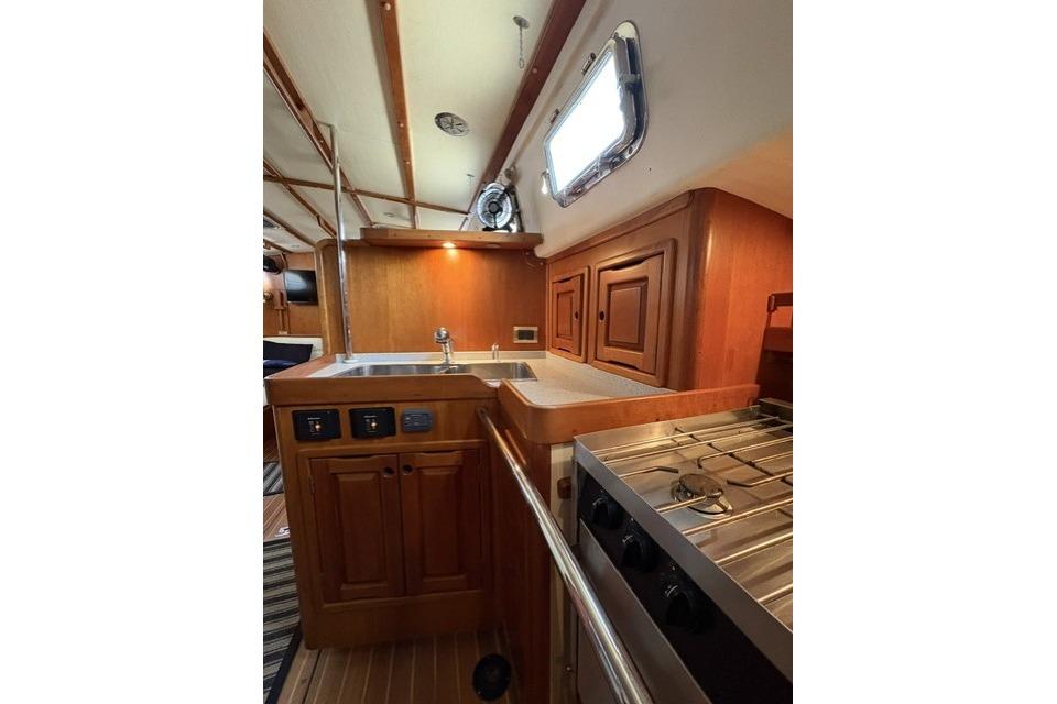 Interior of 2002 Saga 43 yacht featuring a wooden galley with stove and sink.
