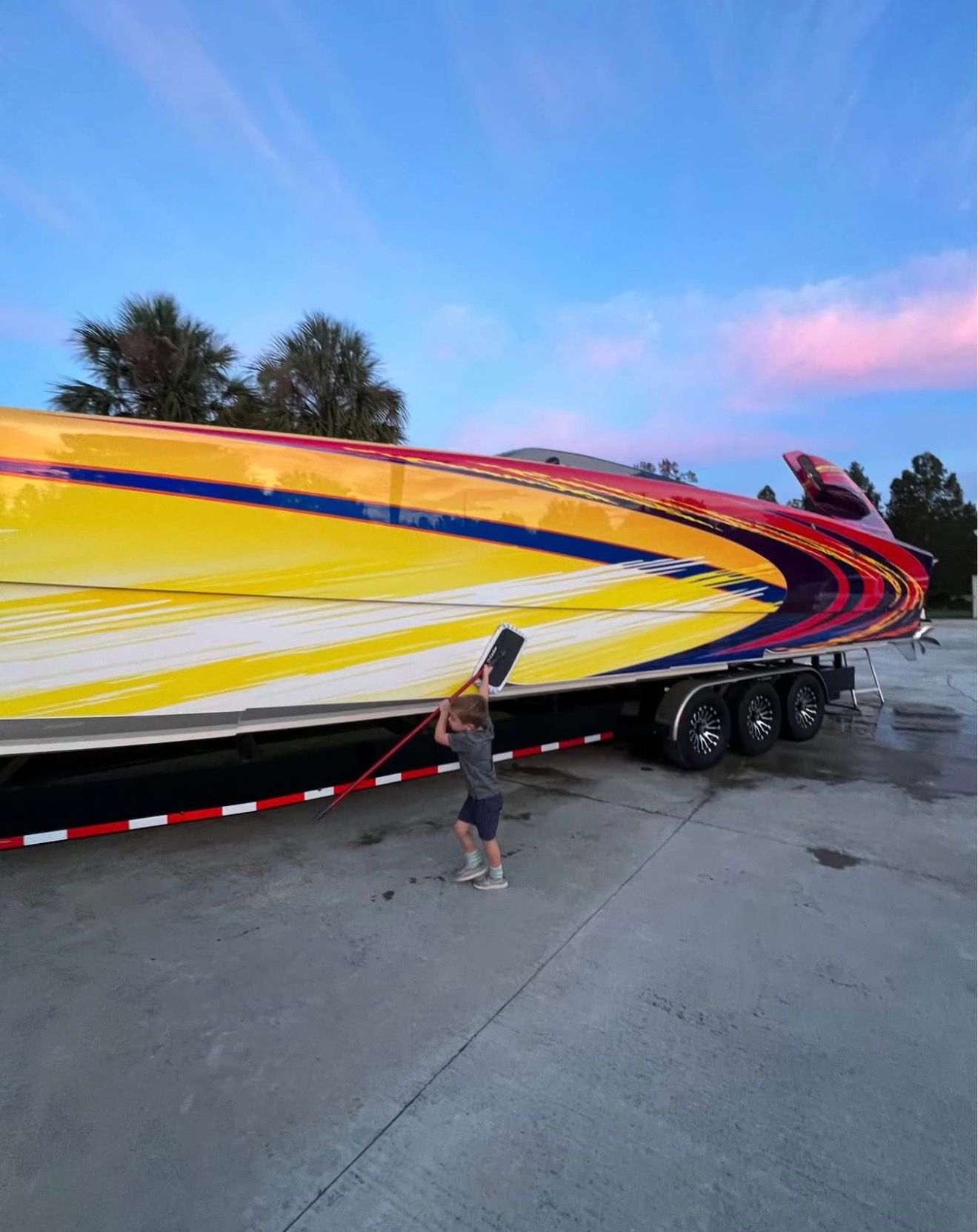 Child cleaning 2003 Skater 40 S.S. boat on trailer.