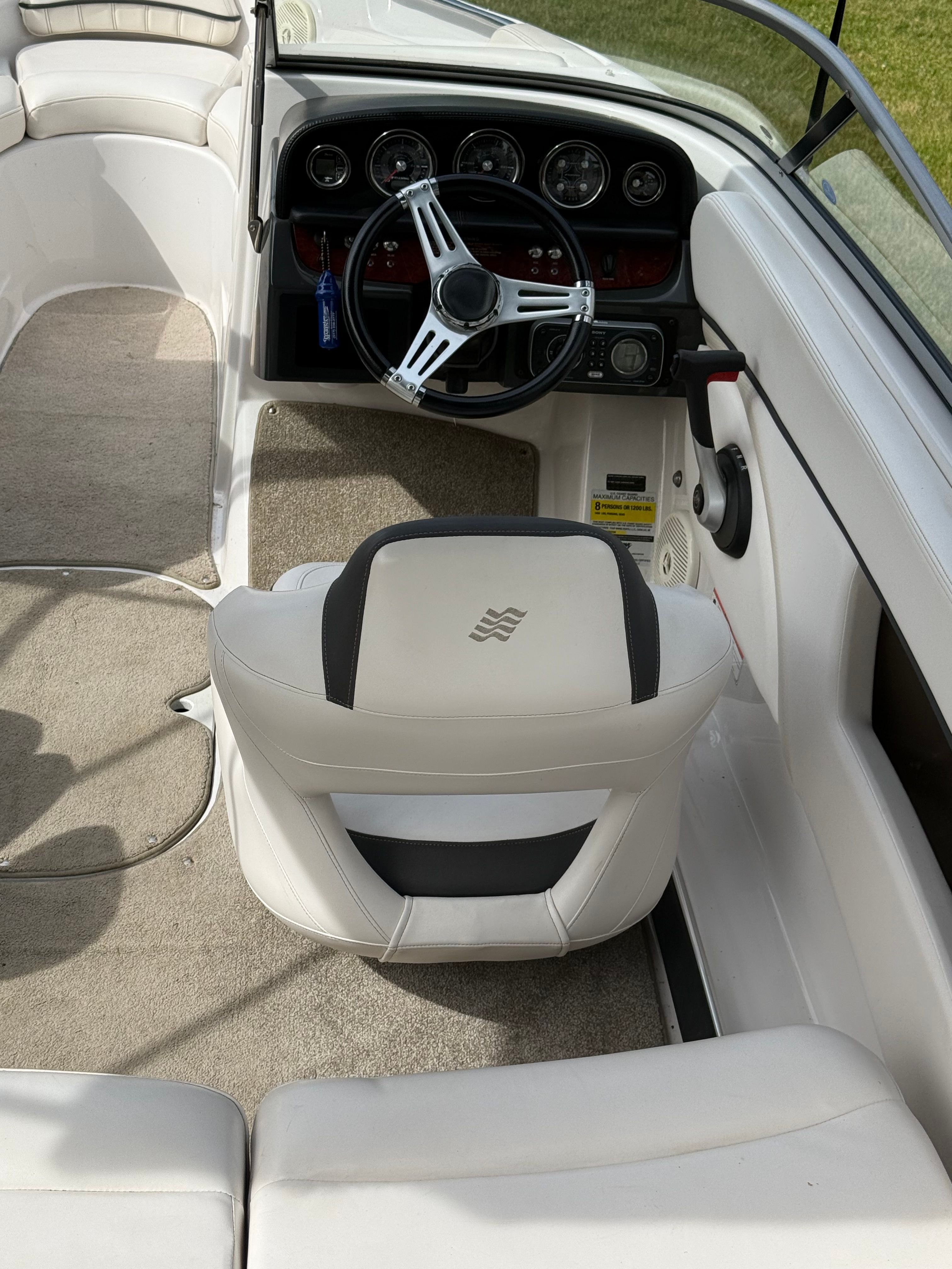 Interior of a 2011 Four Winns H200 with white upholstery and a modern dashboard.