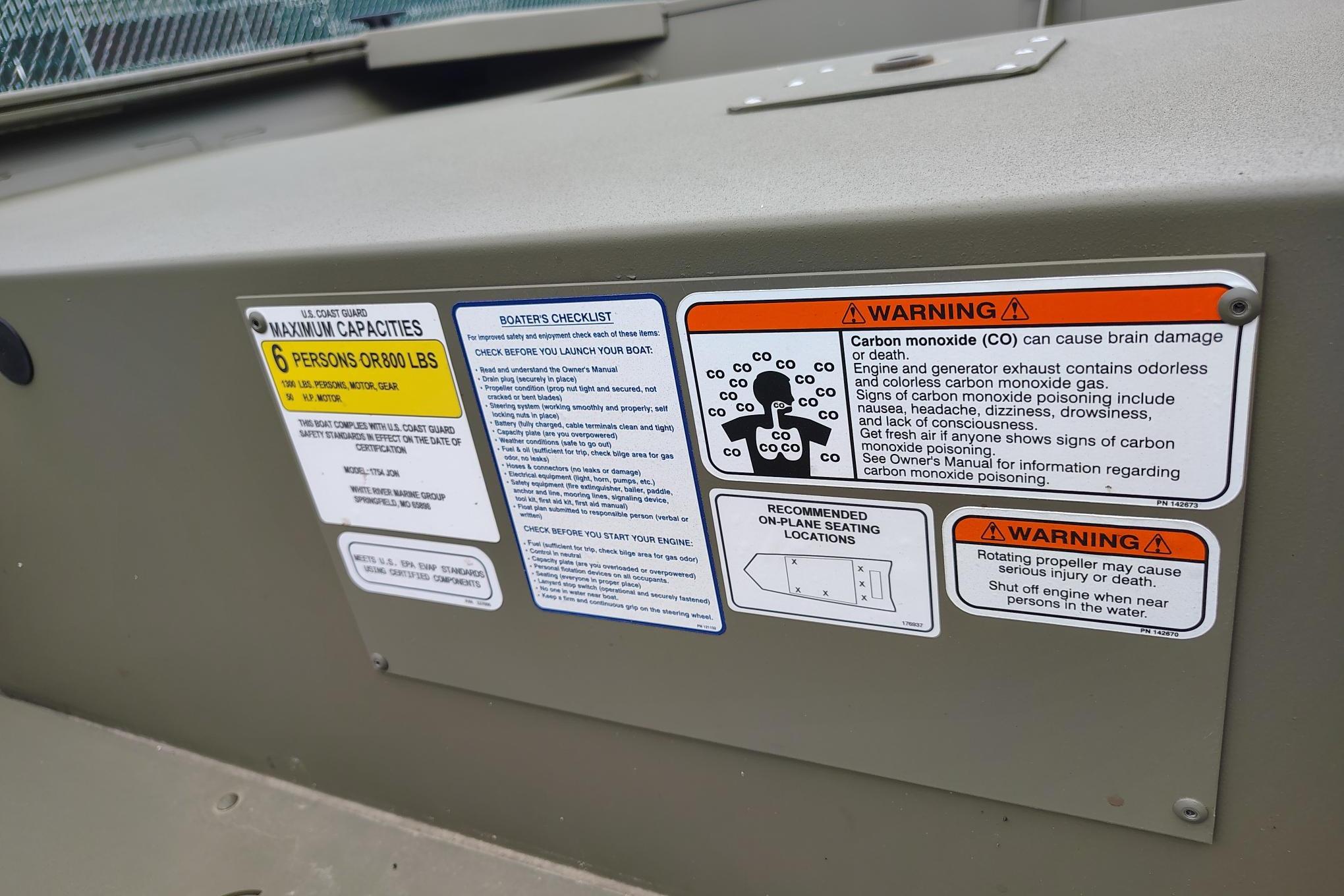 Warning labels on 2026 Tracker Grizzly 1754 Utility boat, including capacity and safety instructions.