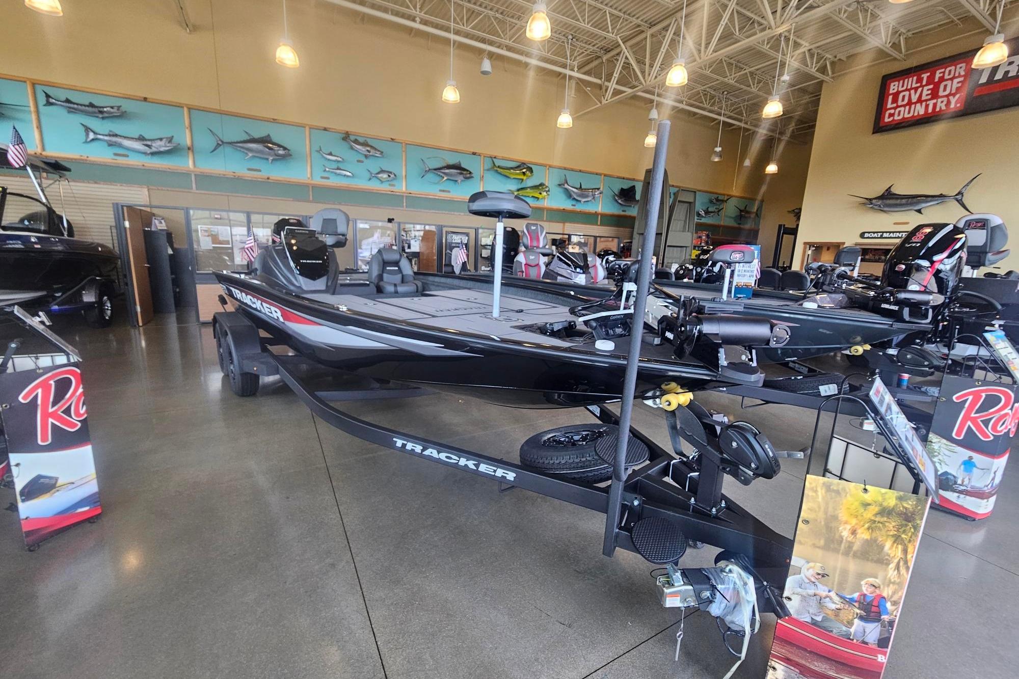 2026 Tracker Savage 215 boat displayed in a showroom with fishing decor.