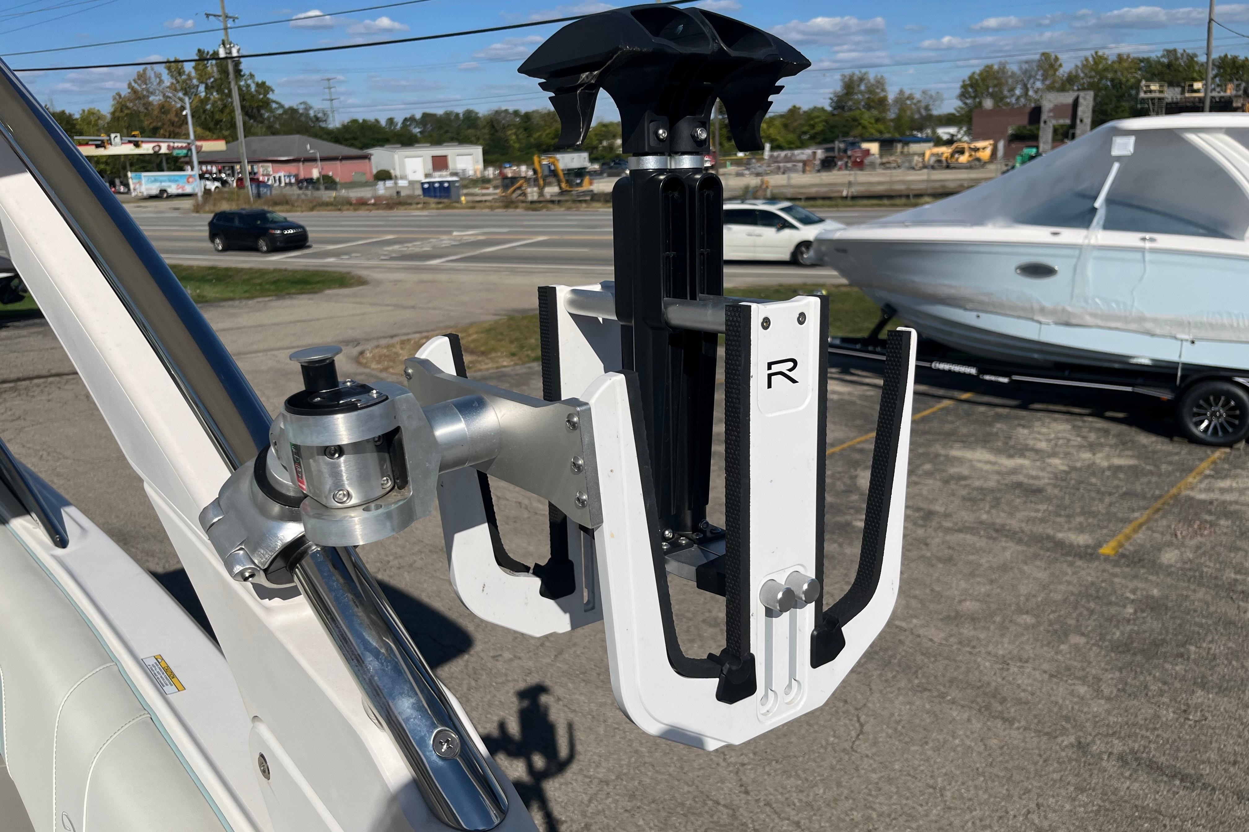 2024 Regal LS9 Surf boat accessory, mounted on a metal rail, with a parked boat in the background.