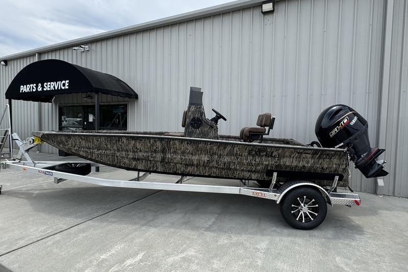 2027 Excel 230 Bay Pro Elite boat on trailer outside parts and service center.